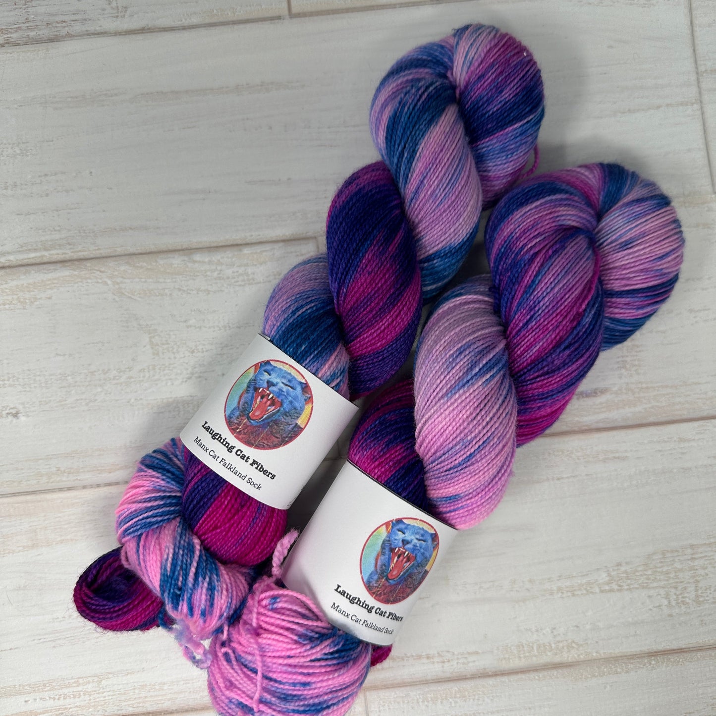 Multicolored skein of yarn with labels on a light wooden surface