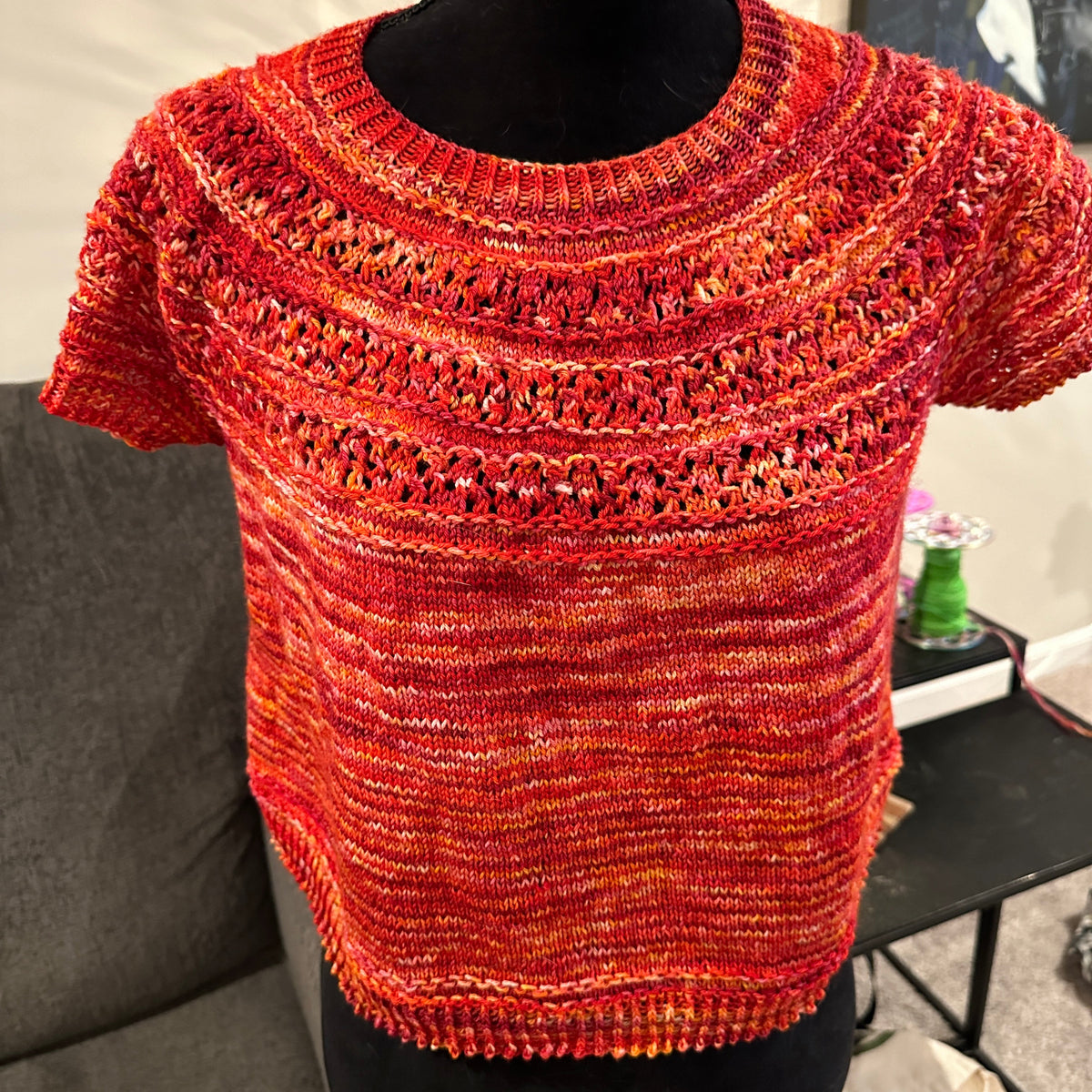 Close-up of a red knitted sleeve with a blurred background
