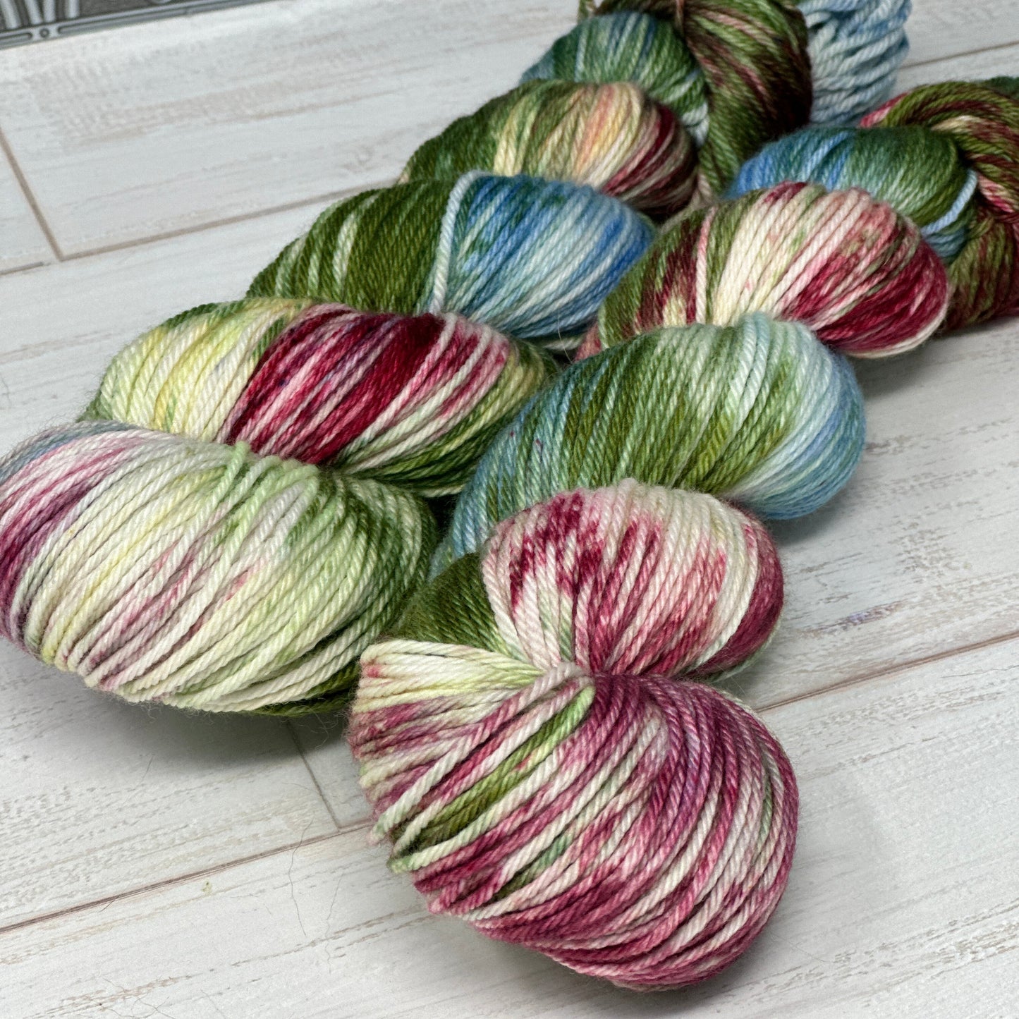 Multicolored yarn skeins on a white wooden surface