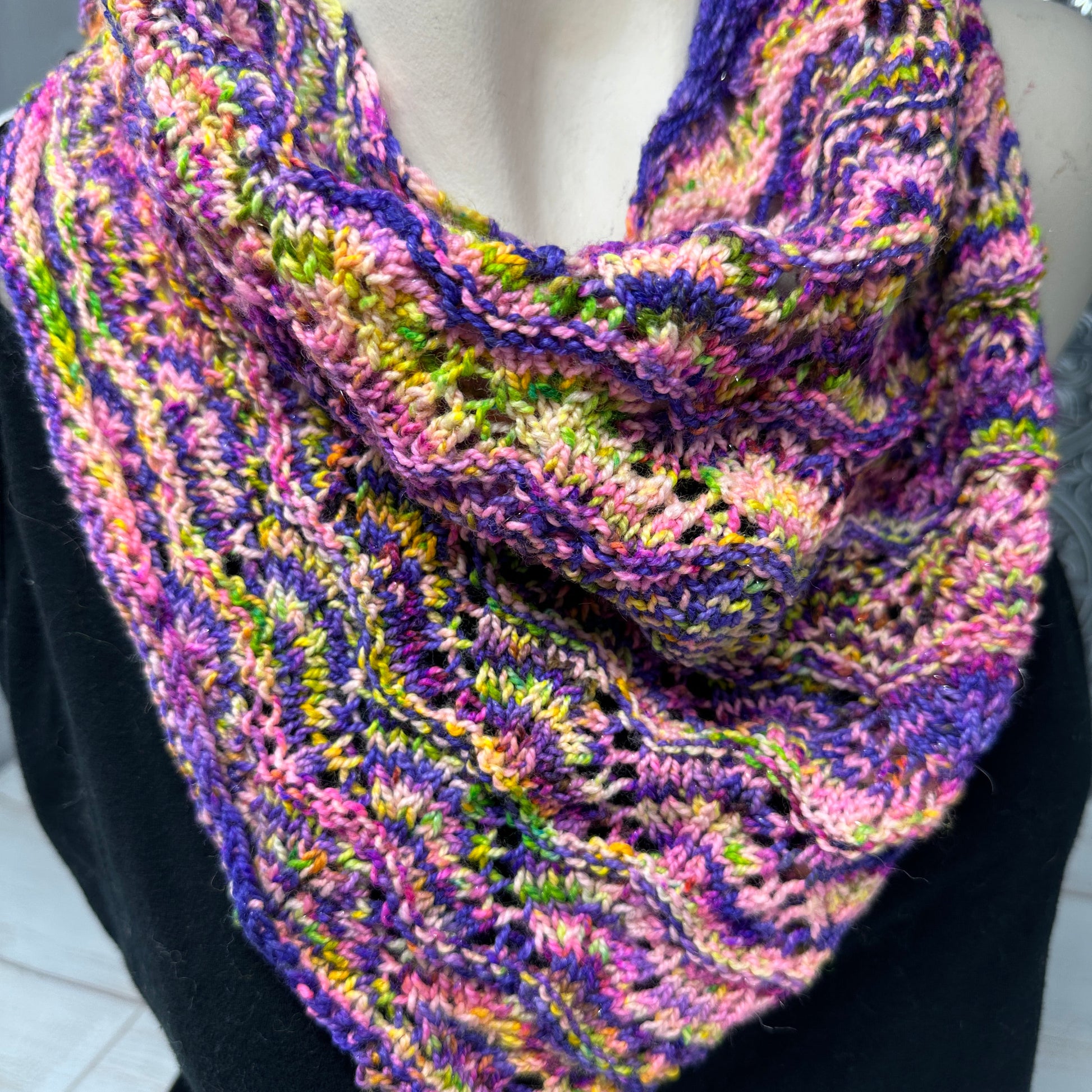 Multicolored knitted scarf on a mannequin against a neutral background