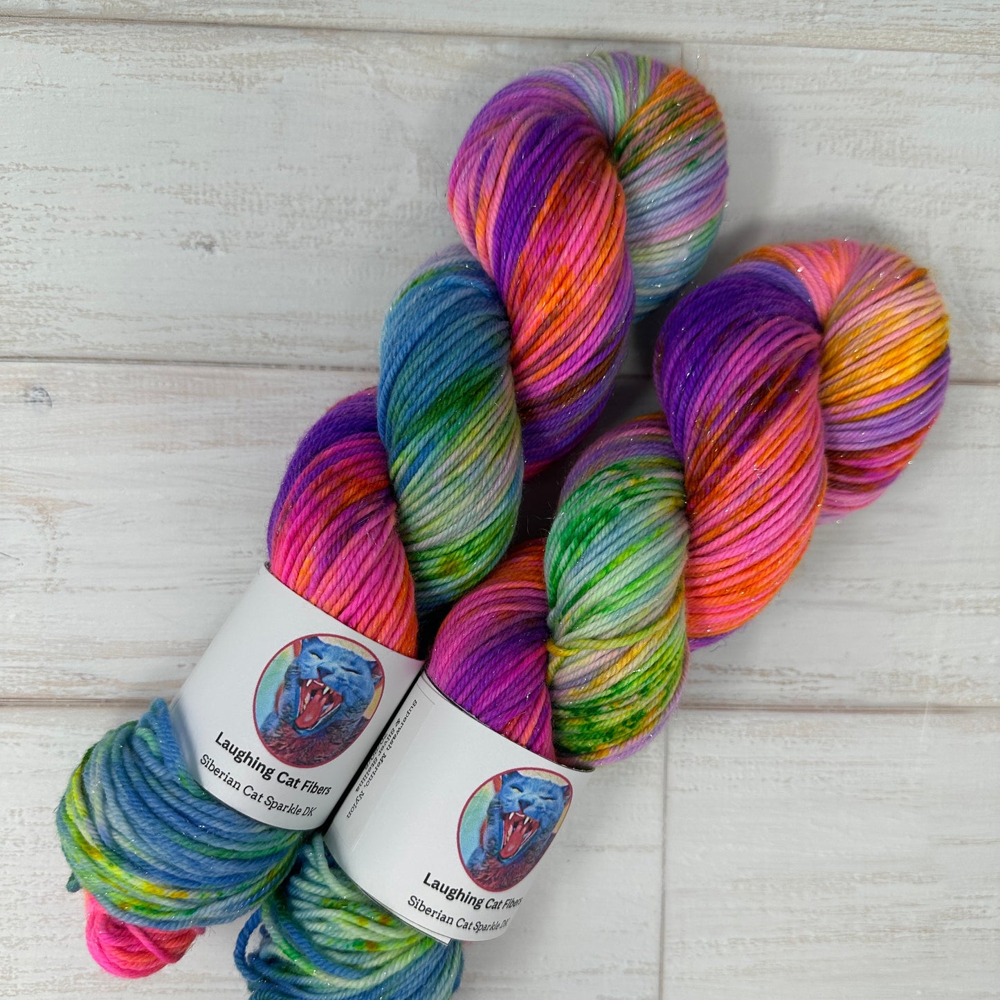 Multicolored skein of yarn with labels on a light wooden surface