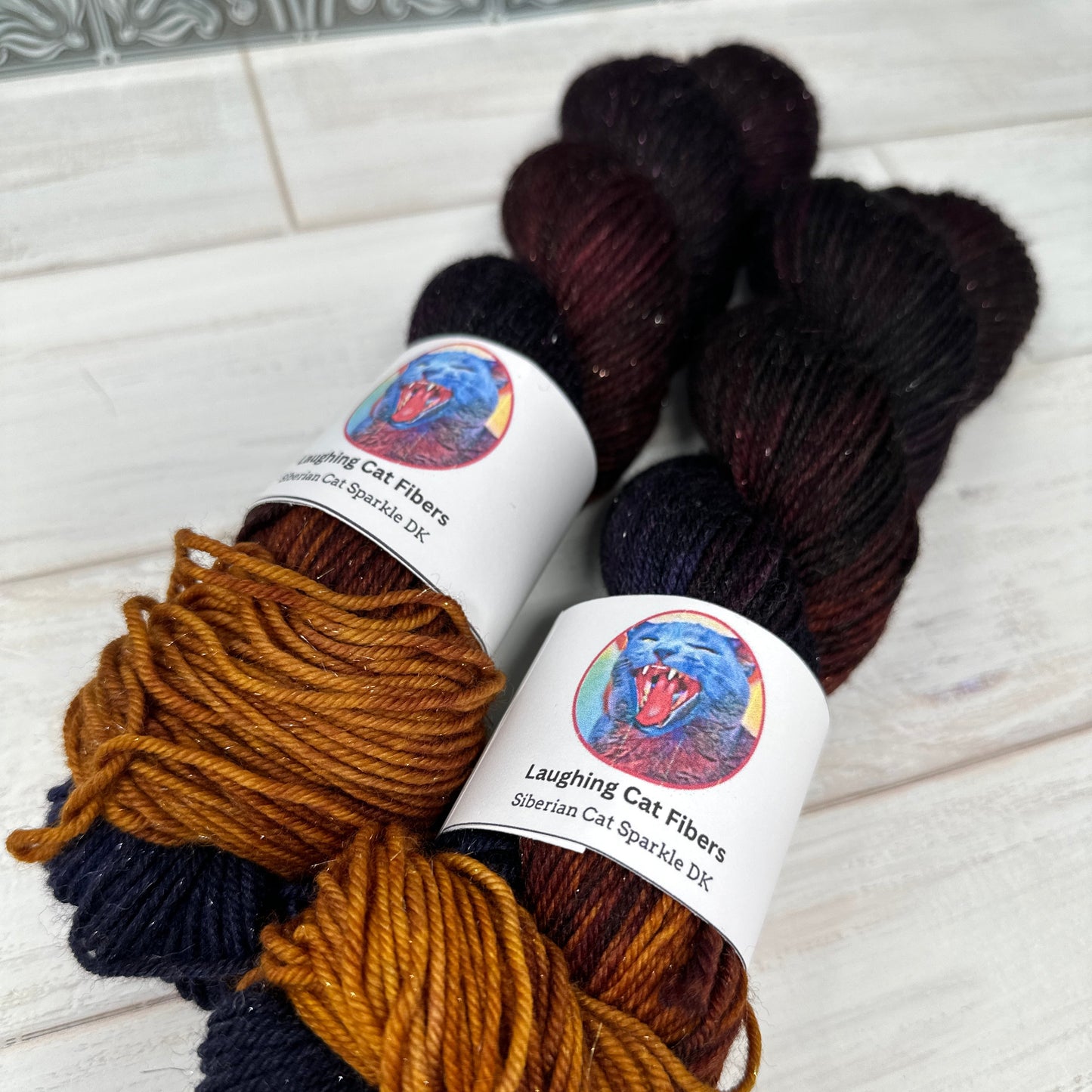 two skeins of sparkle DK yarn hand dyed by Laughing Cat Fibers in their Judith colorway 