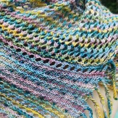Close up of a shawlette knit with beads and yarn hand dyed by Laughing Cat Fibers in their Flor de Selva 