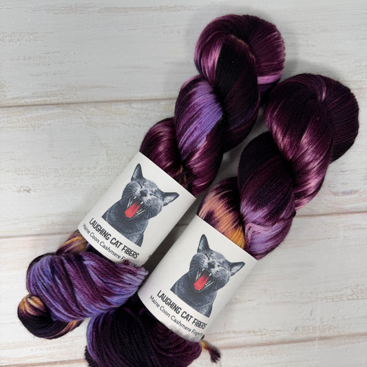 two skeins of yarn with purple and peach and dark burgandy