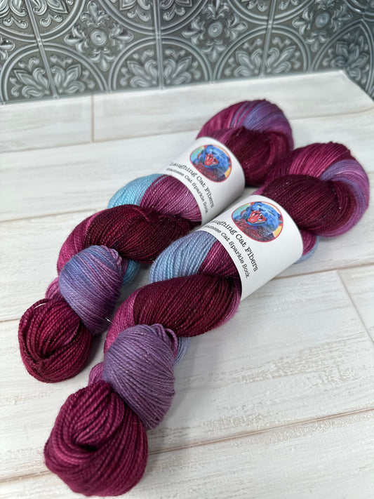 Three skeins of multicolored yarn on a white wooden surface.