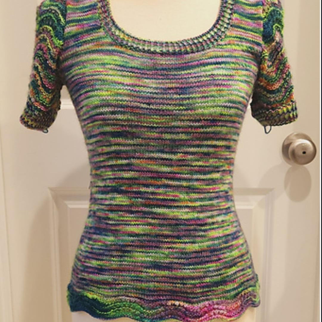 Multicolored knitted top on a mannequin against a white door background