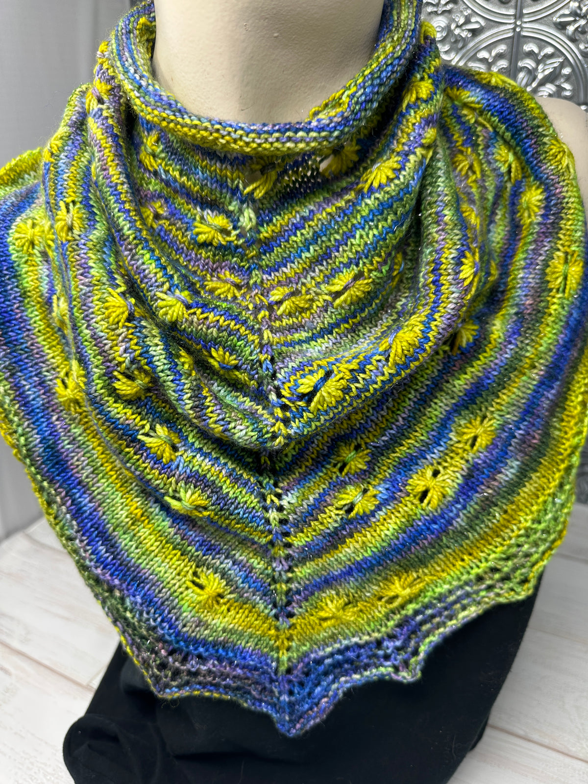 Knitted shawl with blue and yellow pattern on a mannequin
