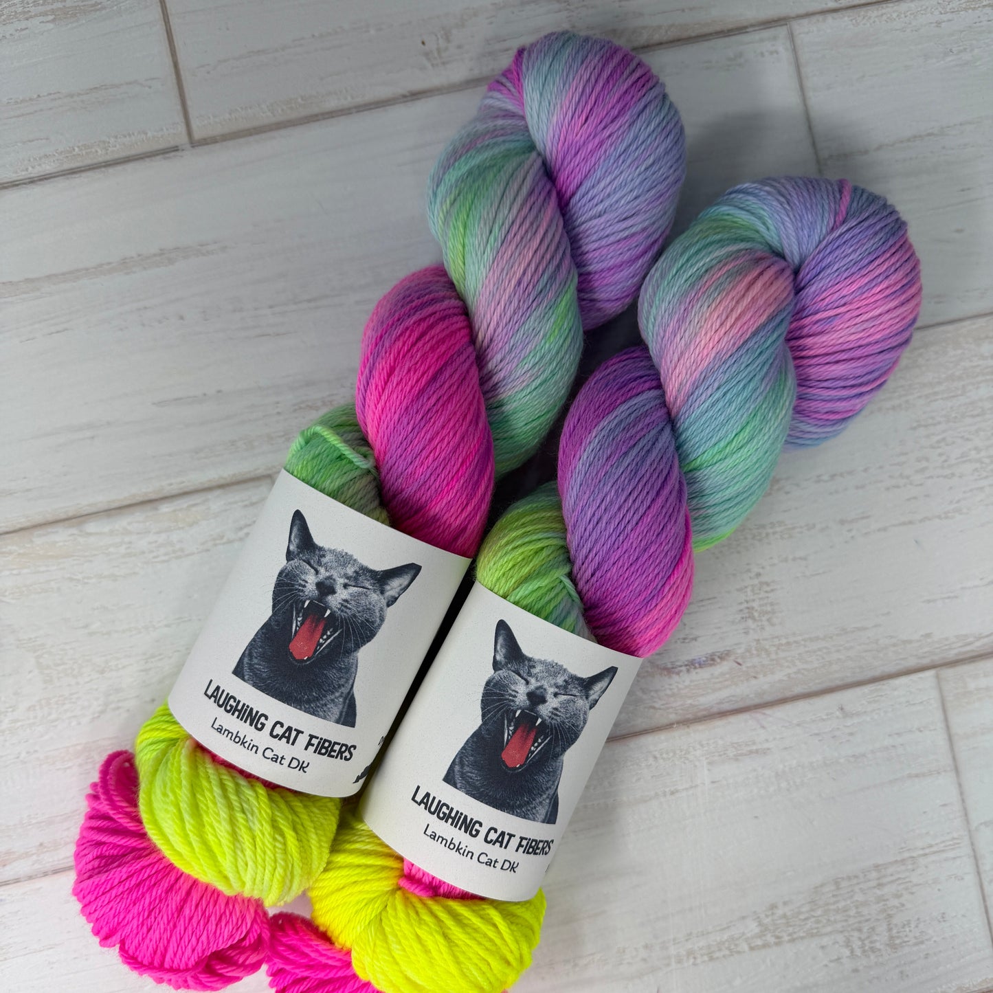 Colorful yarn skeins with labels on a light wooden floor