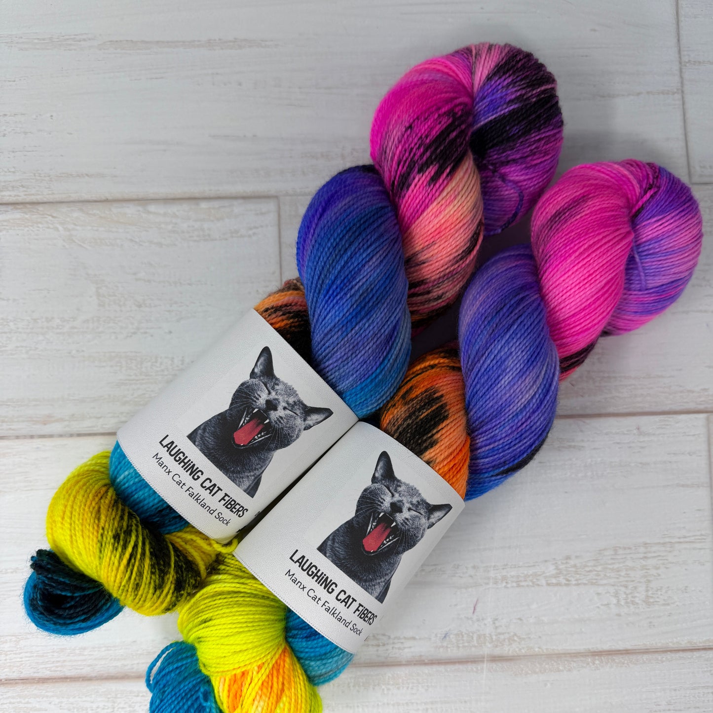 Colorful skeins of yarn with labels on a light wooden surface