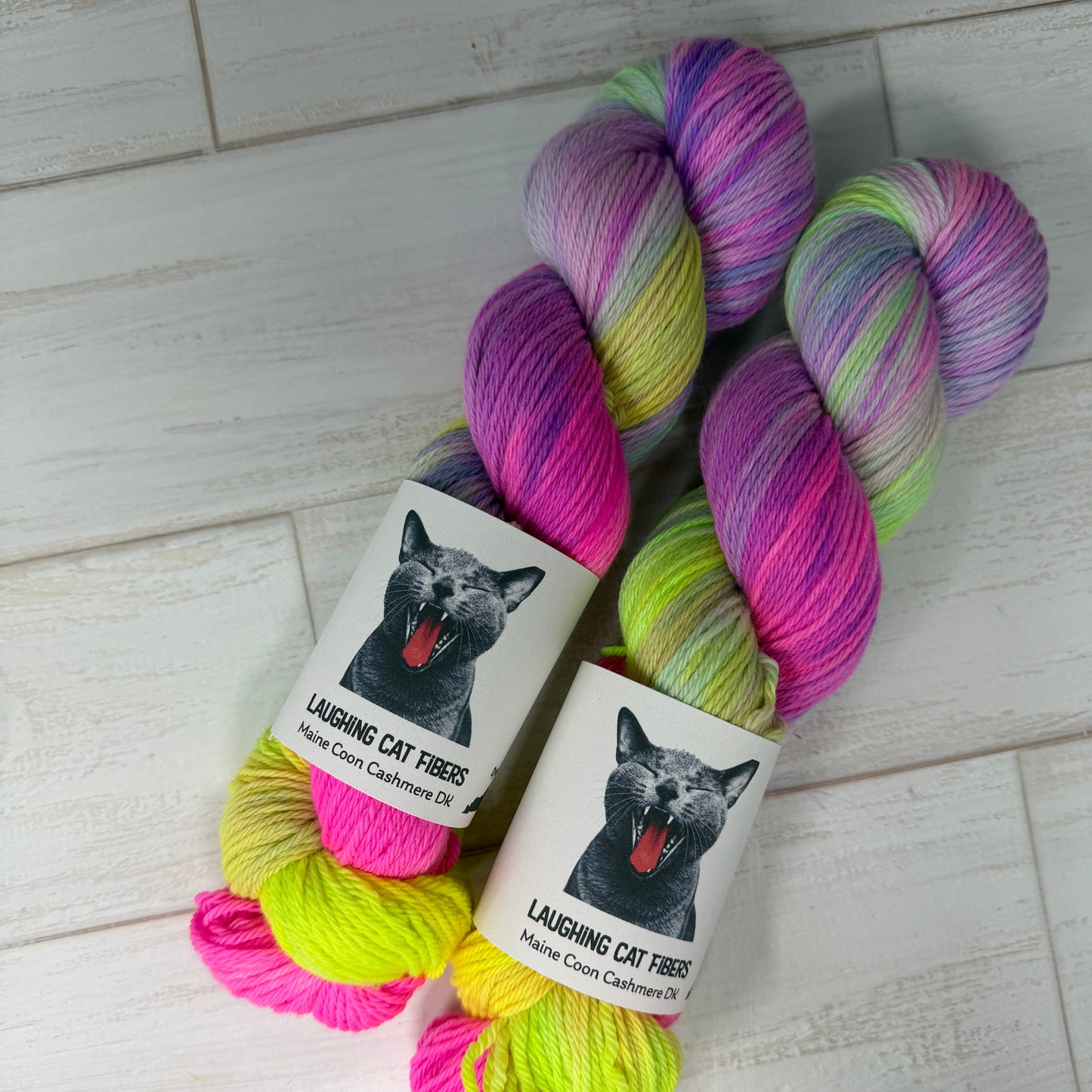 Colorful skein of yarn with matching packaging on a light wooden surface