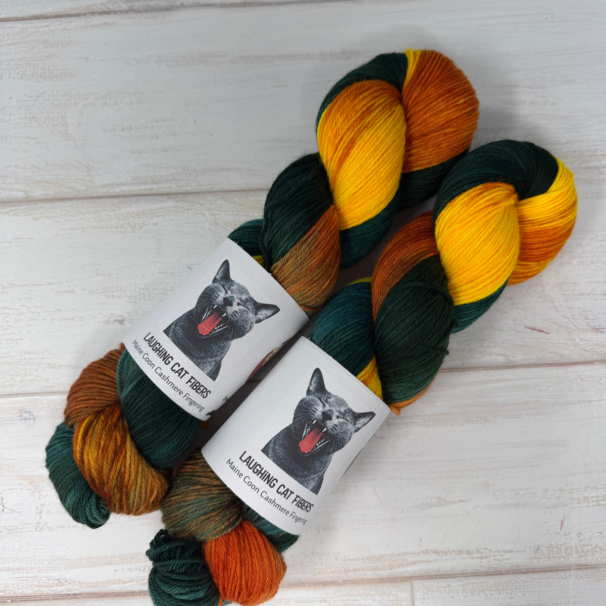 2 skeins of Laughing Cat Fibers UV reactive yarn in the Goldfish colorway