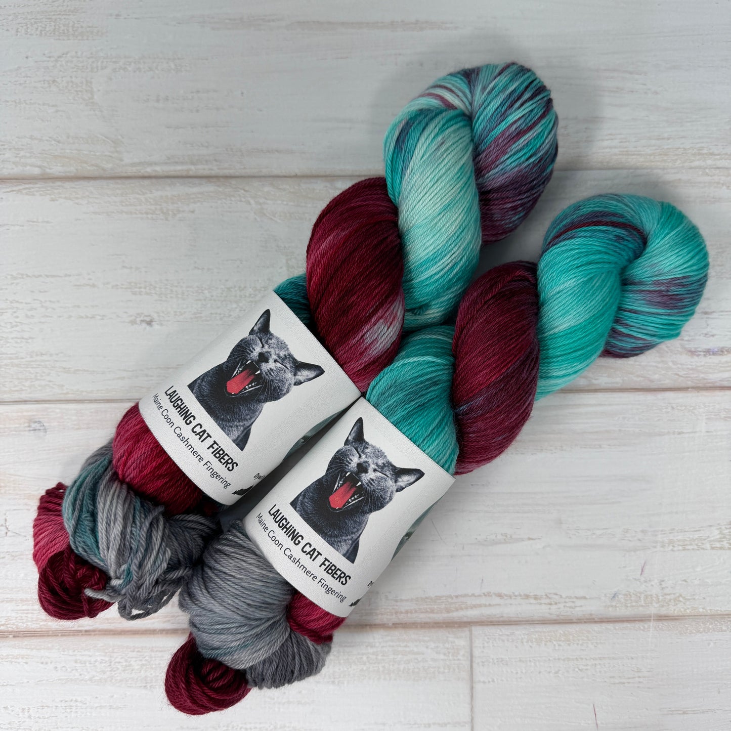 Multicolored skeins of yarn with labels on a light wooden surface