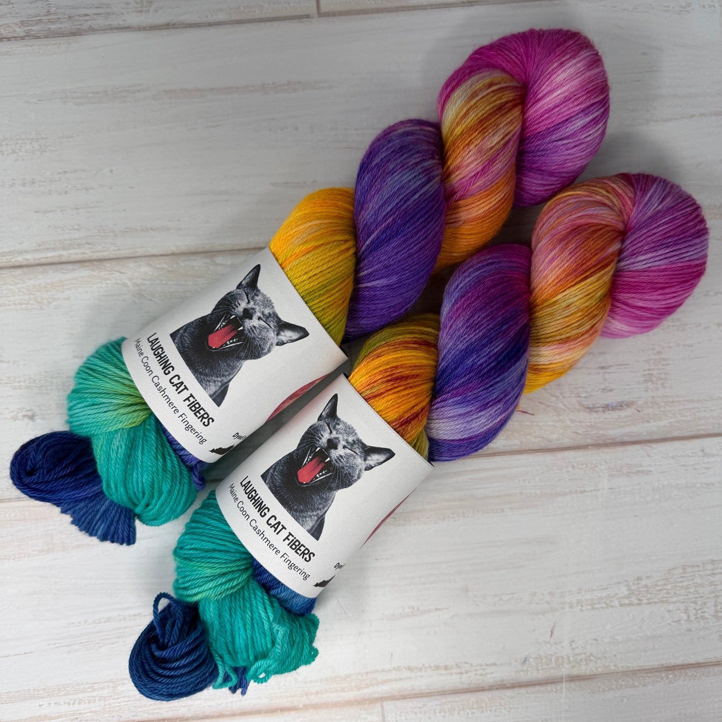 Colorful skeins of yarn with labels on a light wooden surface
