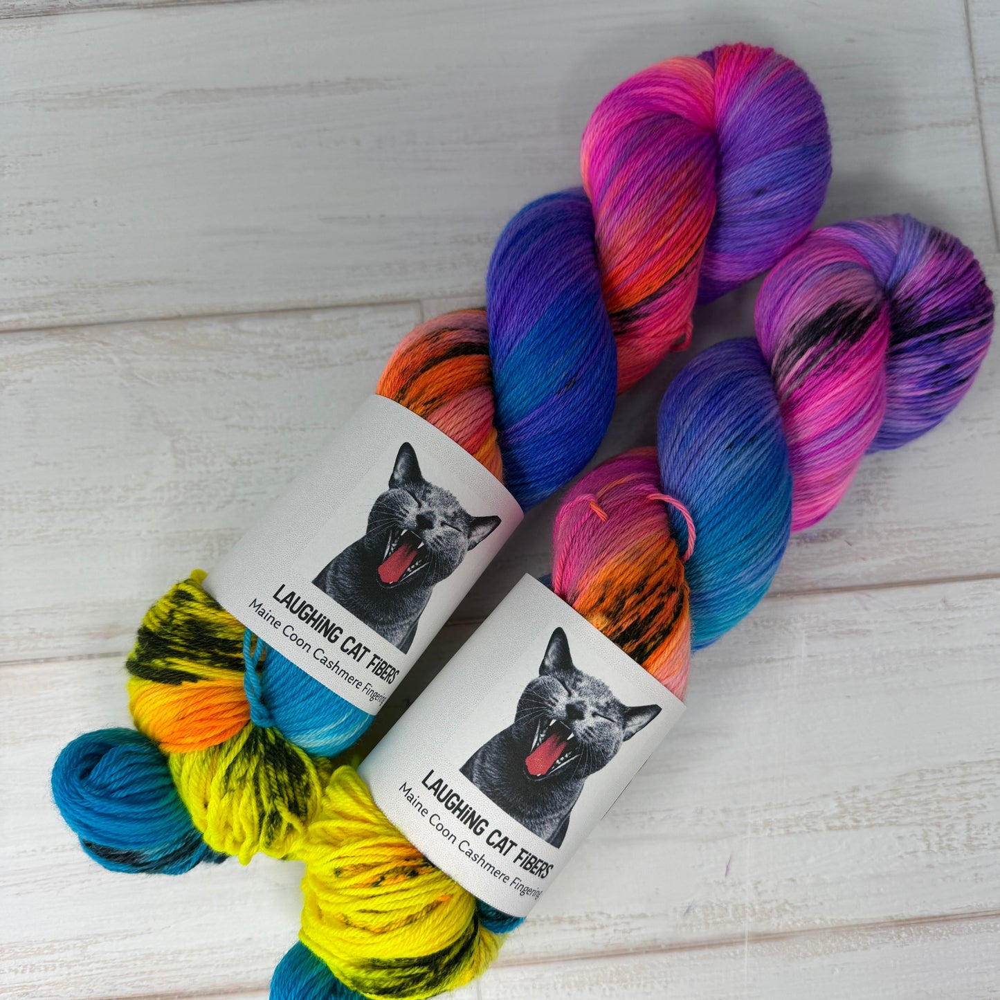 Colorful skein of yarn with labels on a light wooden surface