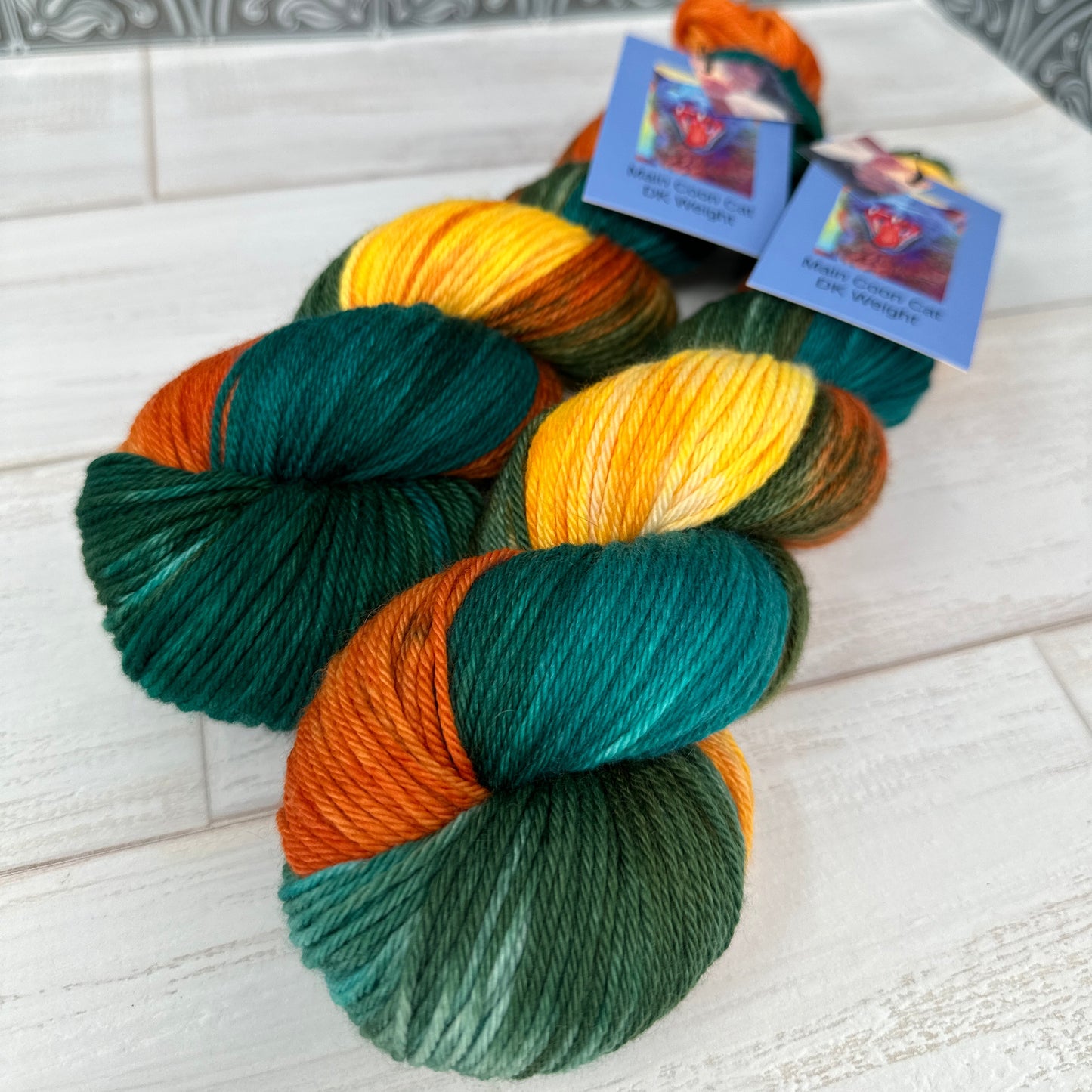 two skeins of MCN DK yarn hand dyed by Laughing Cat Fibers in their Goldfish colorway 