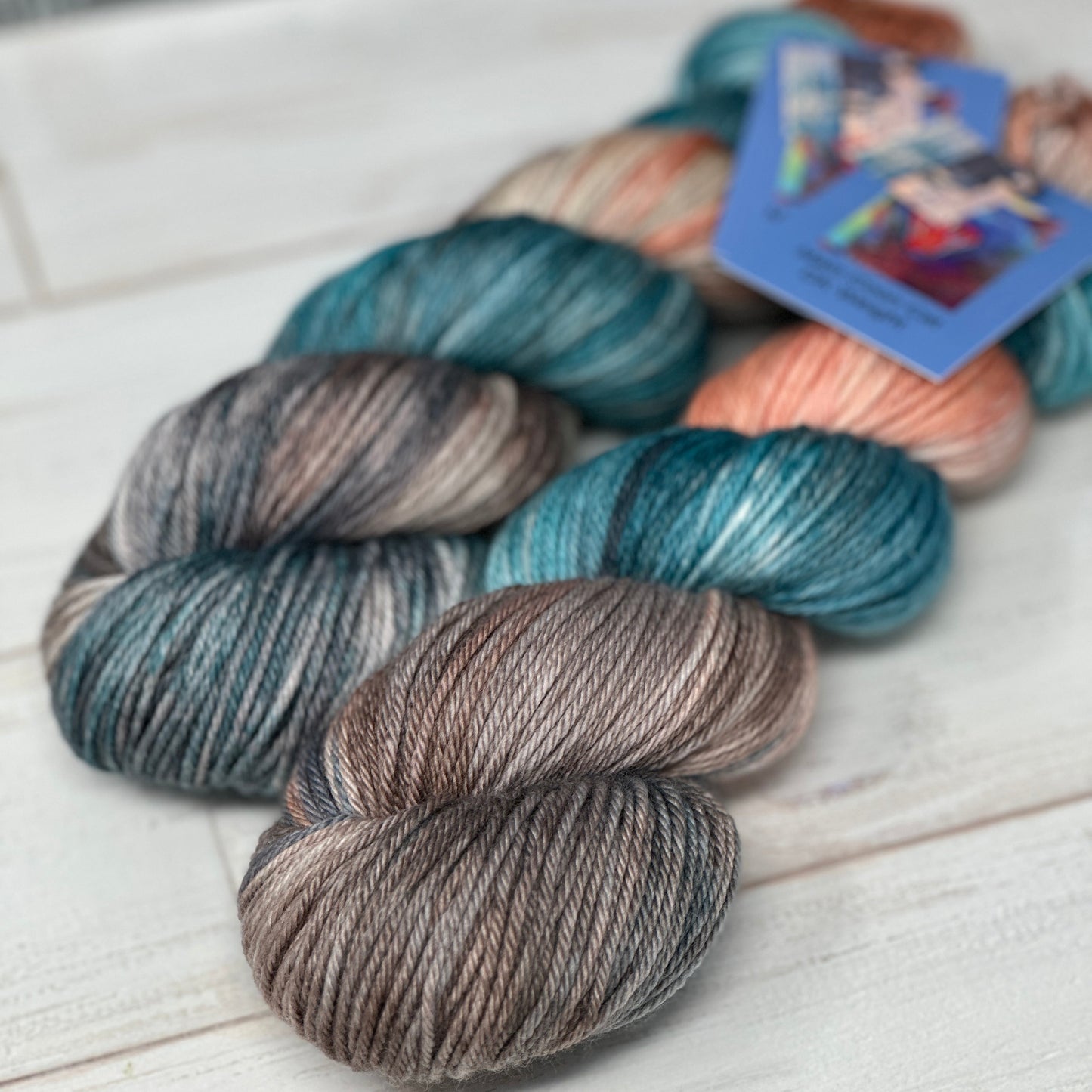 Three skeins of multicolored yarn on a white surface with a blurred background