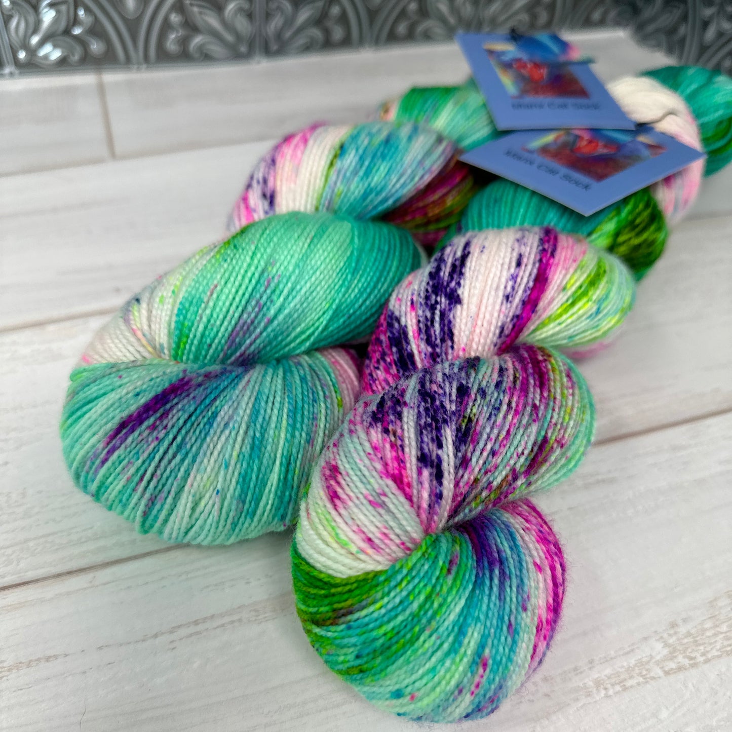two skeins of multicolored hand dyed yarn by Laughing Cat Fibers in the Aurora Borealis colorway