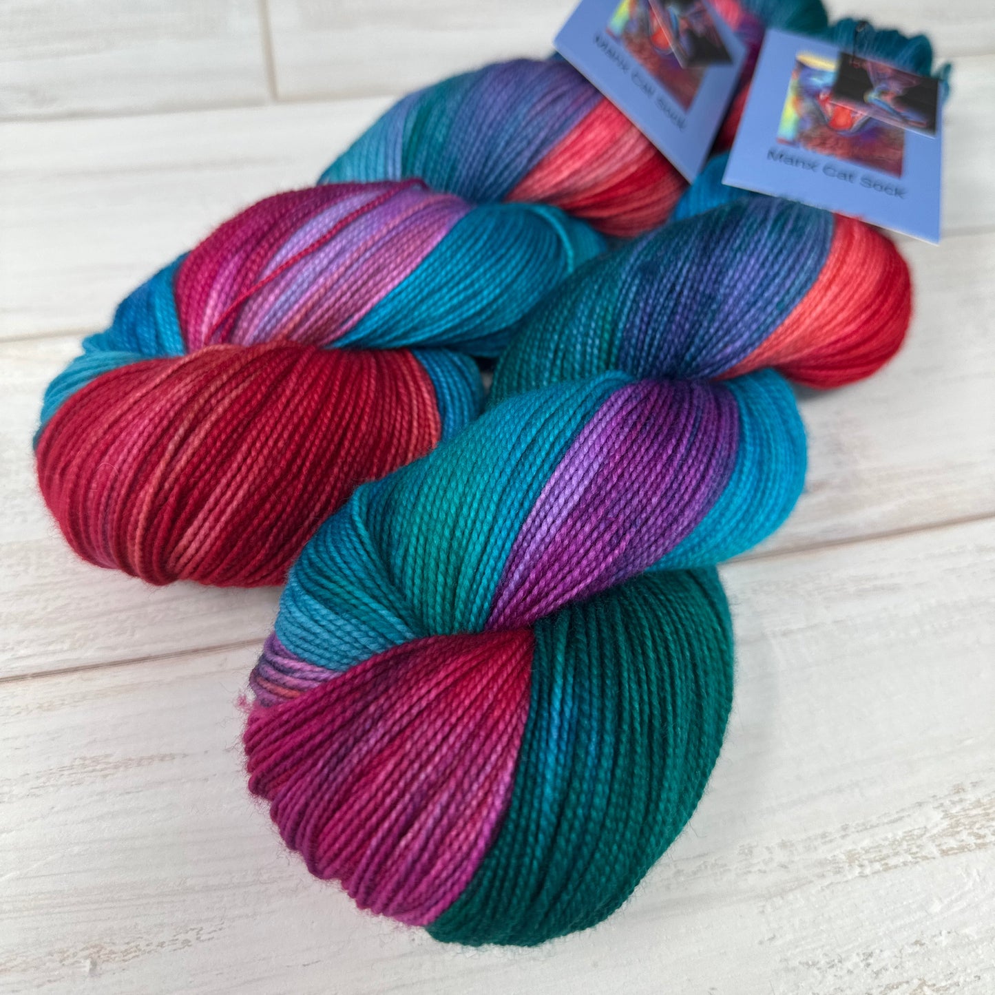 Two skeins of Manx Cat Falkland yarn hand dyed by Laughing Cat Fibers in their Glamping at the Lake colorway 