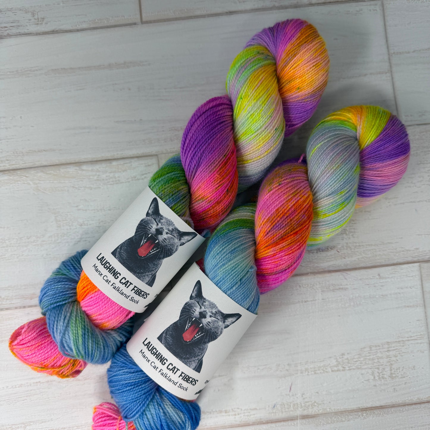 Colorful yarn skeins with dog-themed labels on a light wooden surface