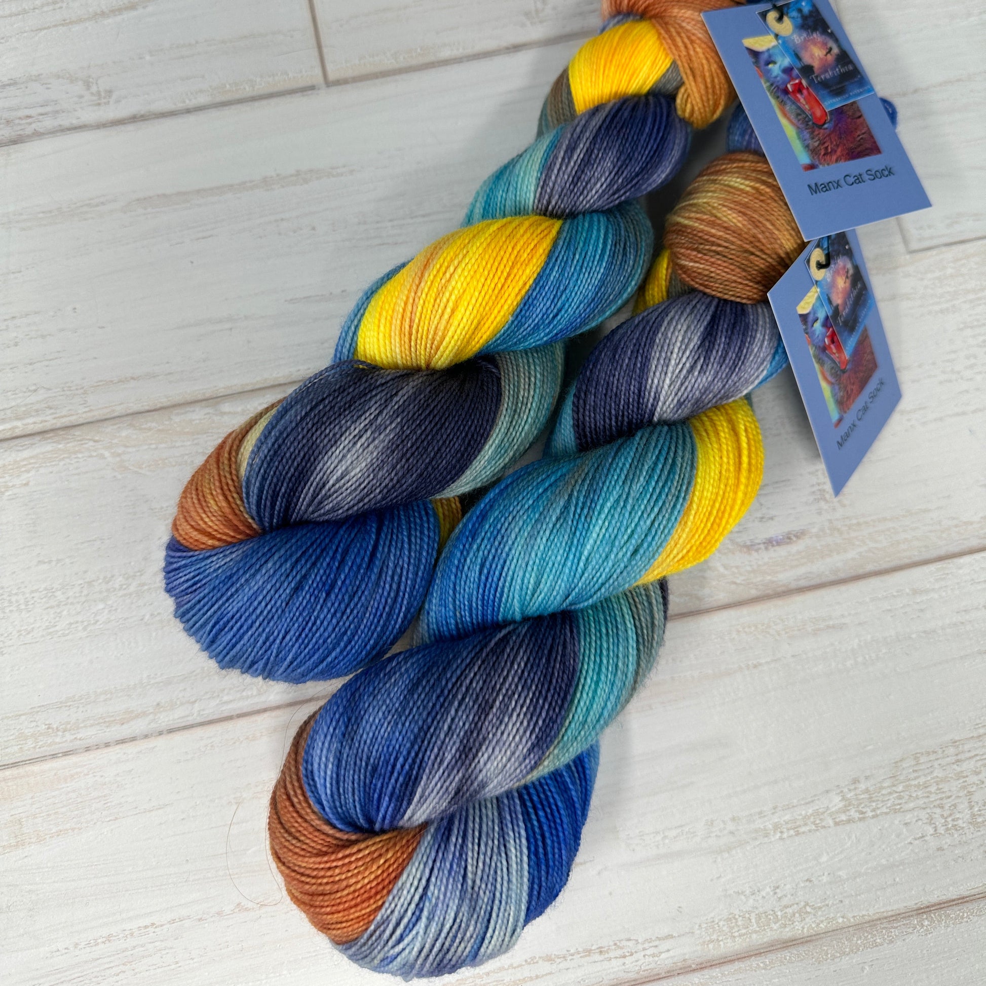Multicolored yarn skein with a tag on a light wooden surface