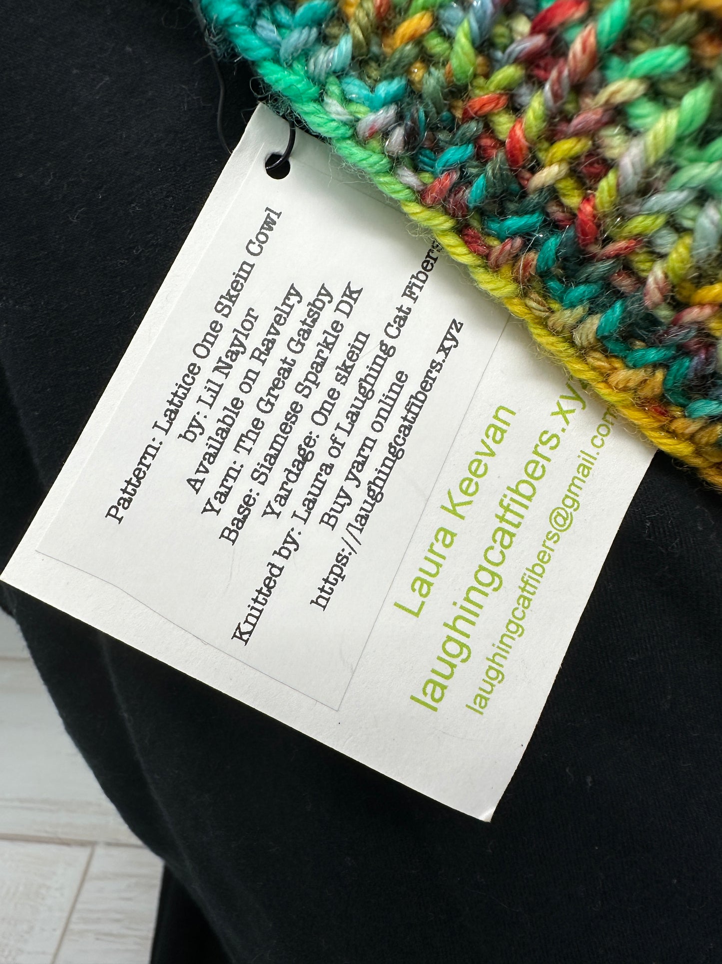 Close-up of a colorful knitted item with a label on a black surface.