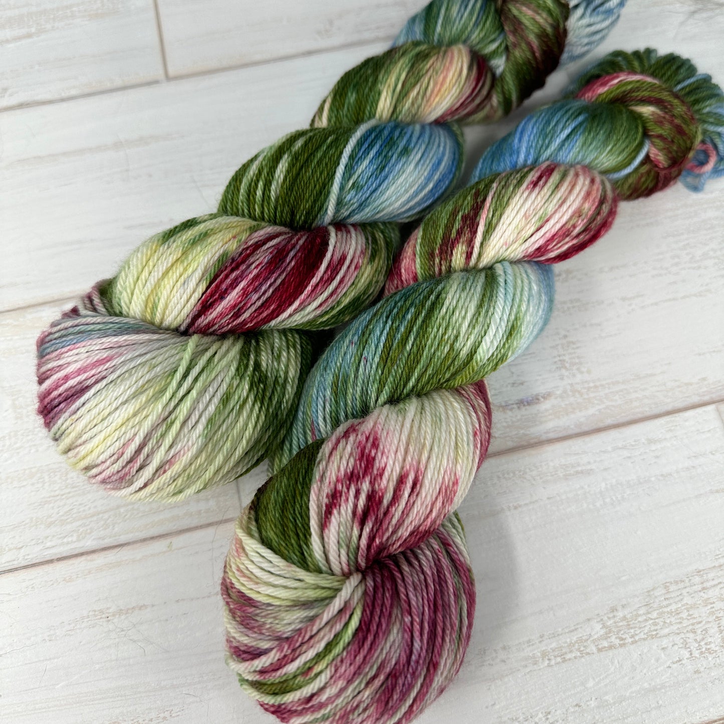 Multicolored yarn skeins on a light wooden surface
