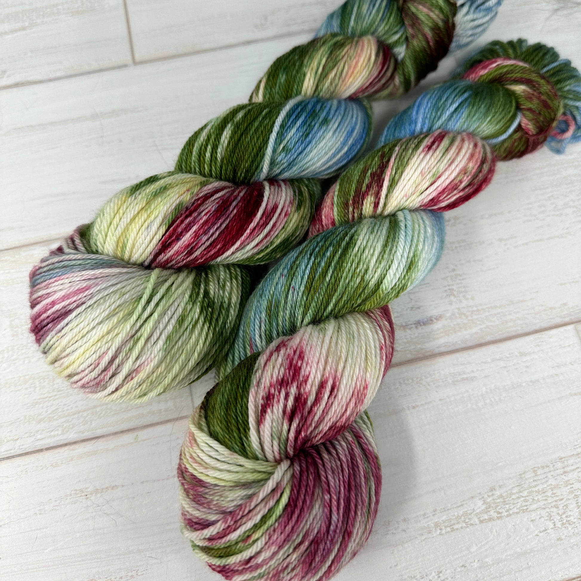 Multicolored yarn skeins on a light wooden surface