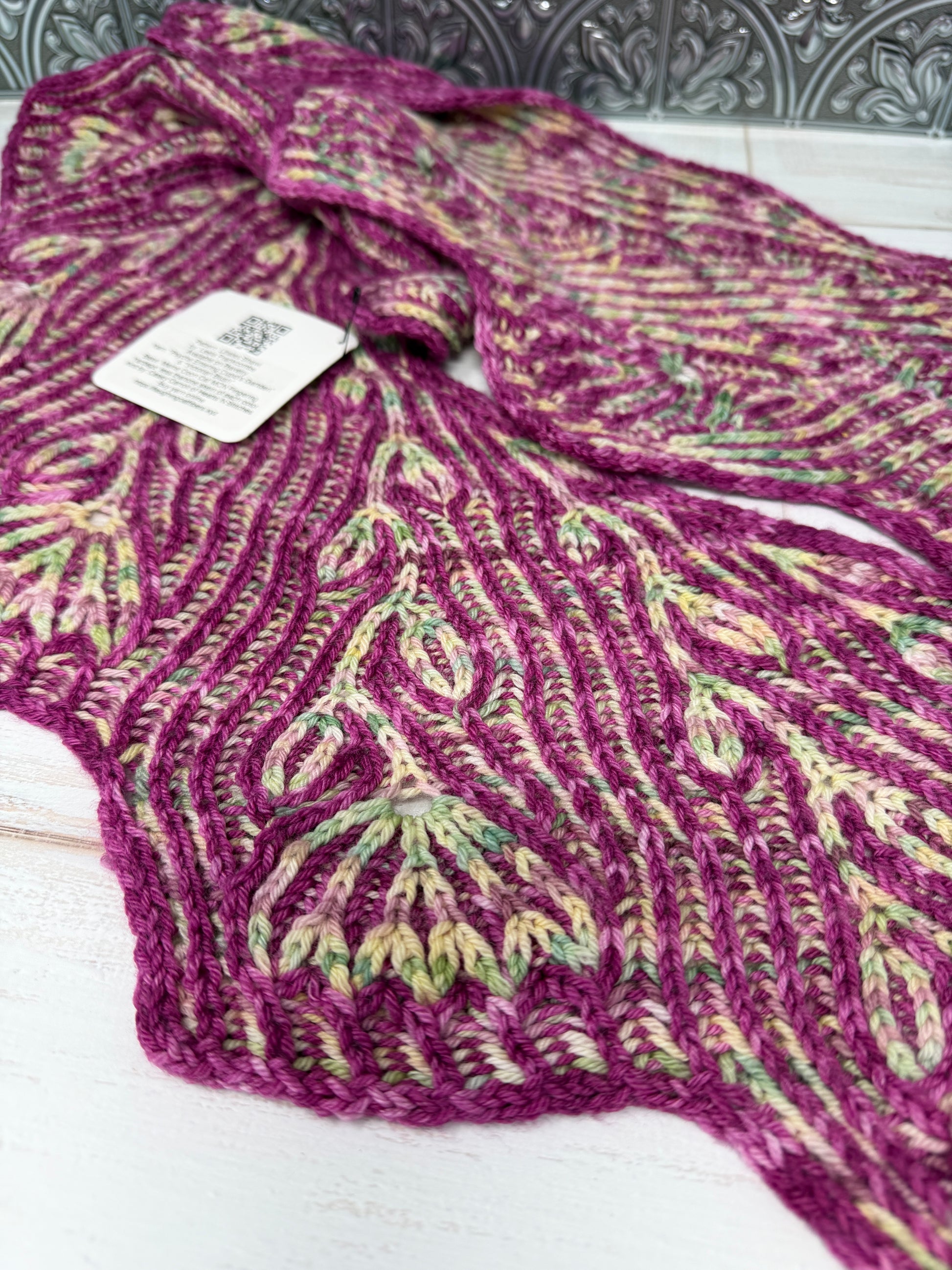 Purple patterned garment with a tag on a white background