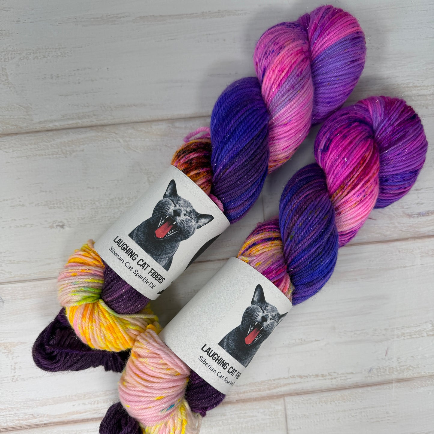 Colorful yarn skeins with labels on a light wooden surface
