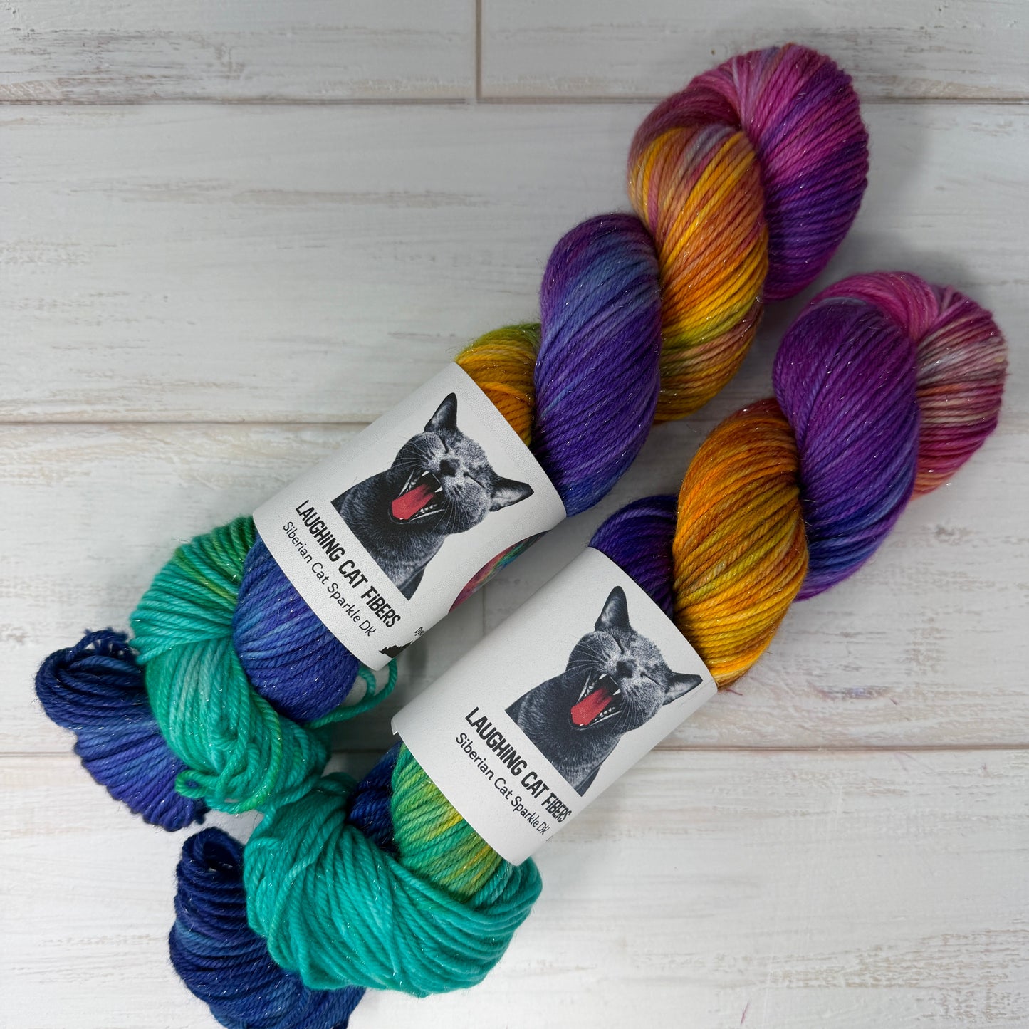 Colorful skeins of yarn with labels on a light wooden surface