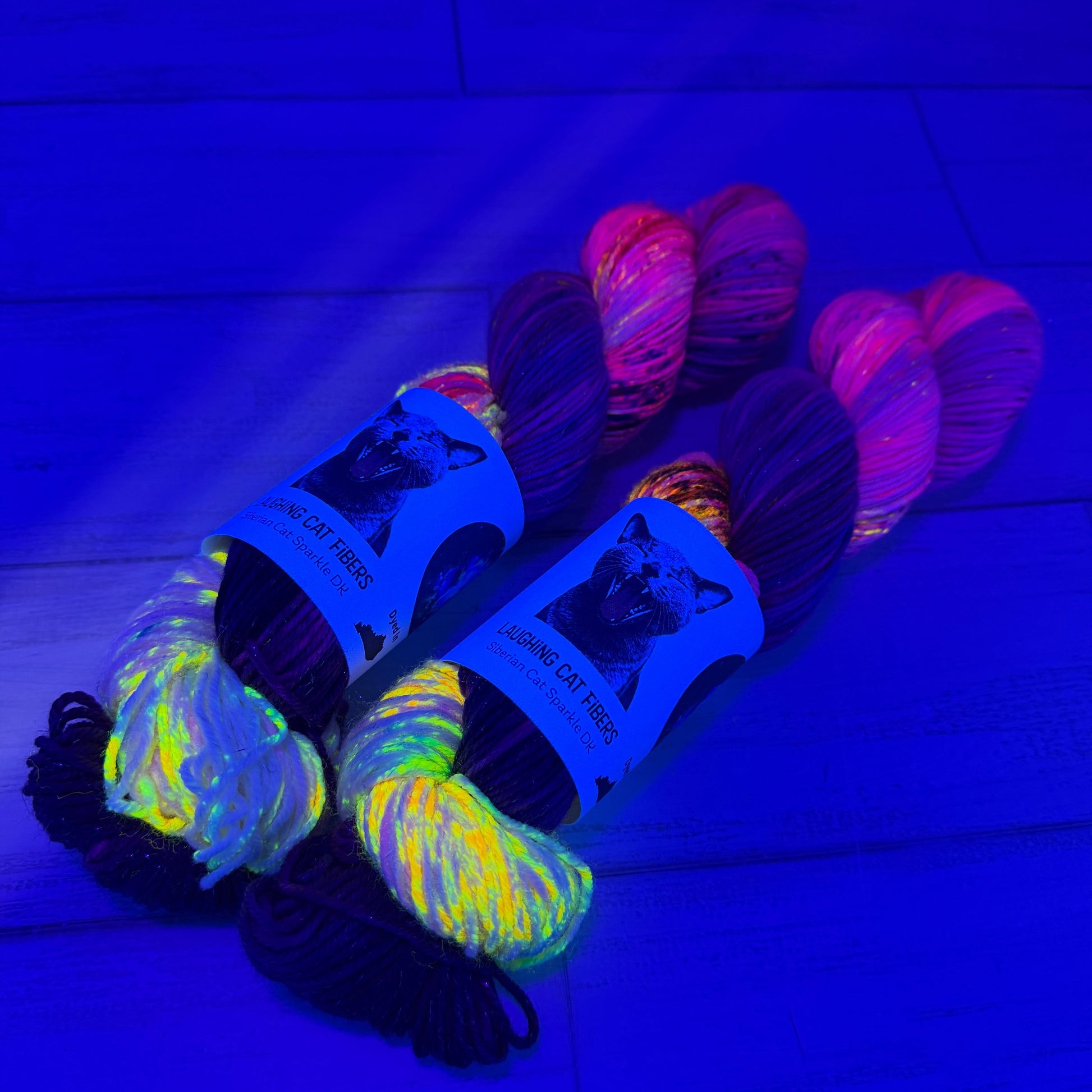 Two skeins of neon yarn  with a brand label on a blue background