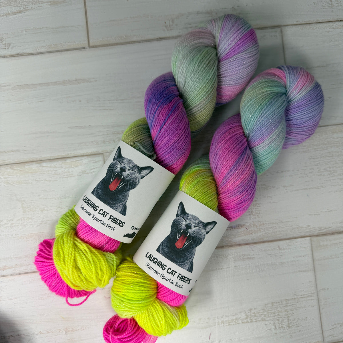 Colorful yarn skeins with a label on a light wooden floor