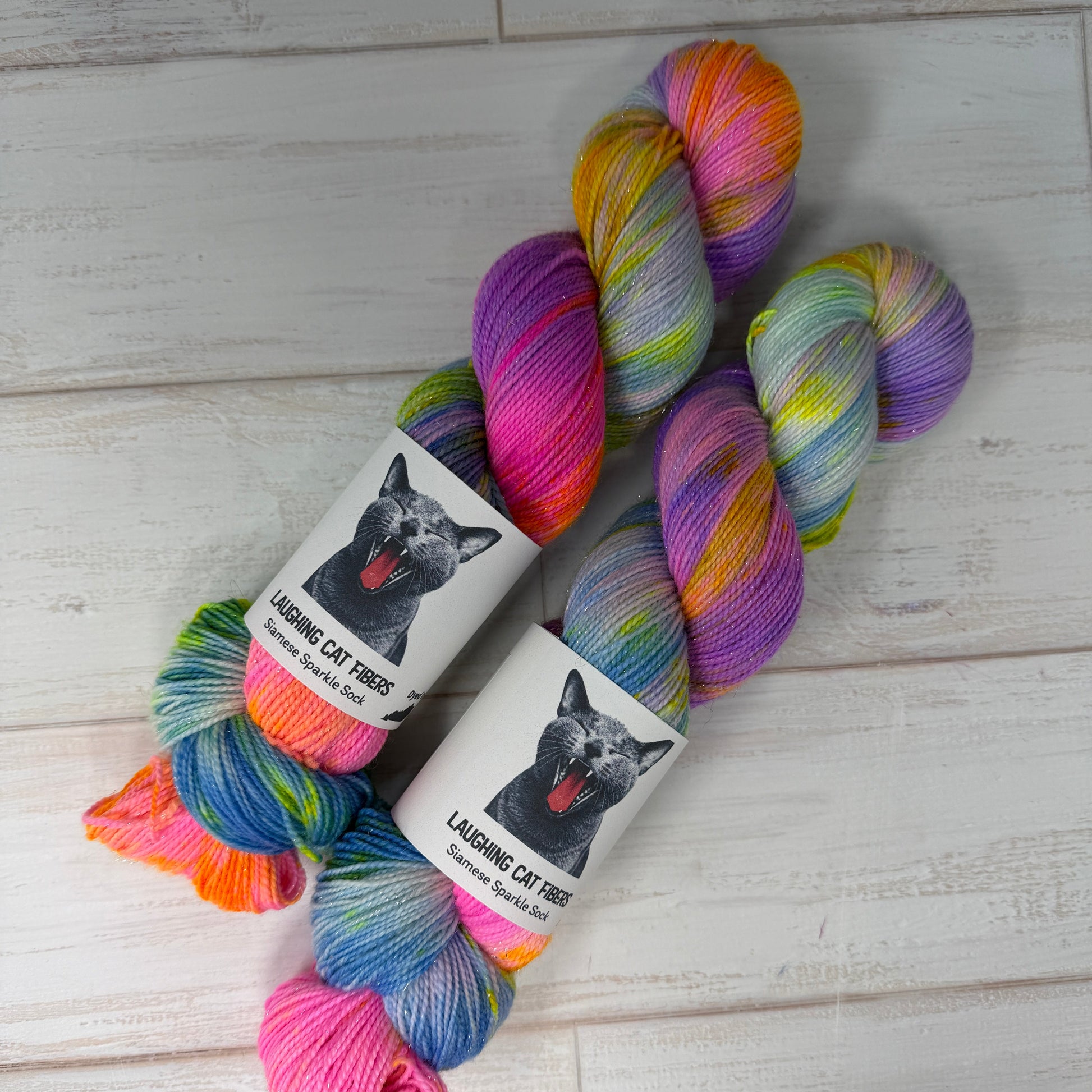 Colorful yarn skeins with labels on a light wooden surface