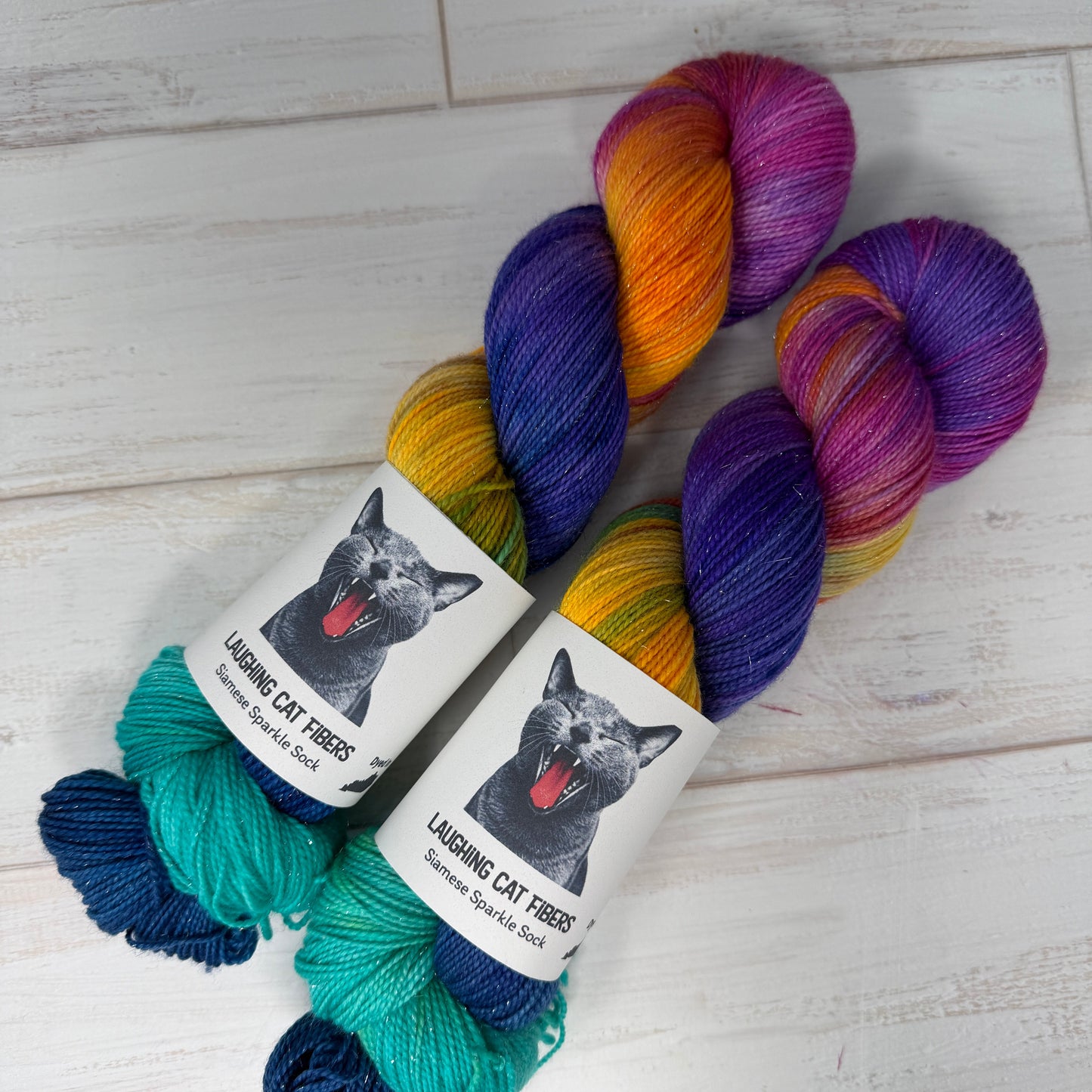 Colorful yarn skeins with a label featuring a cat on a wooden surface