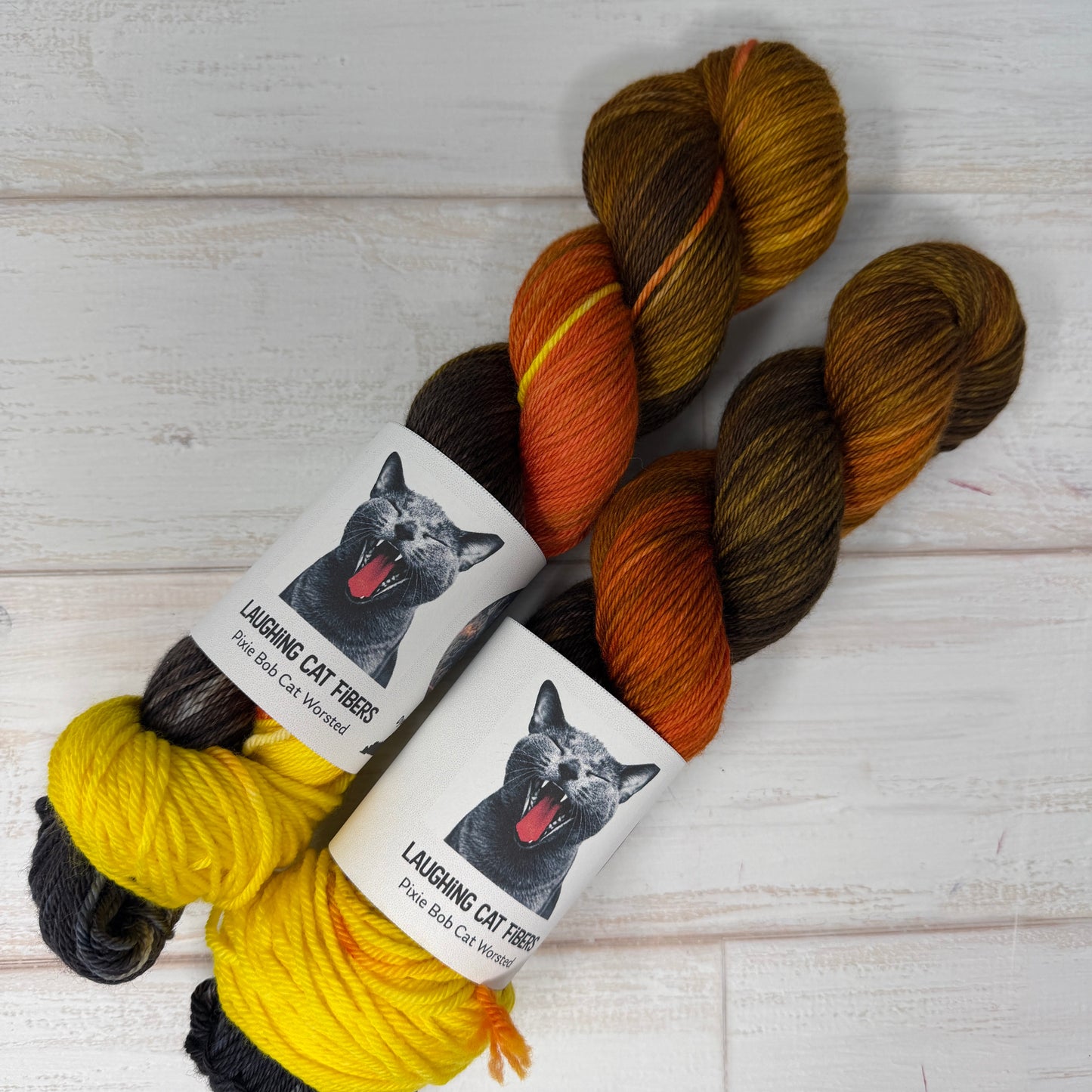 Three skeins of yarn with labels featuring a dog on a light wooden background