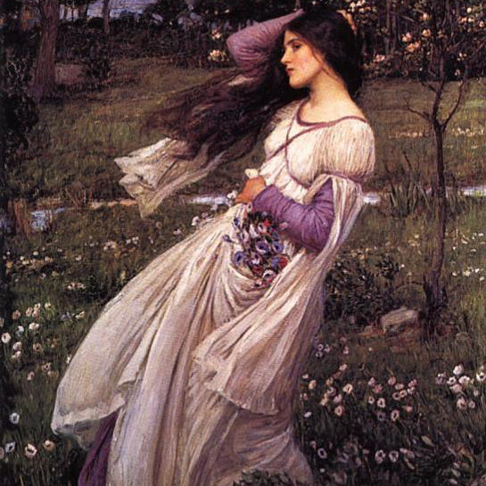 Woman in a flowing dress holding flowers in a garden setting
