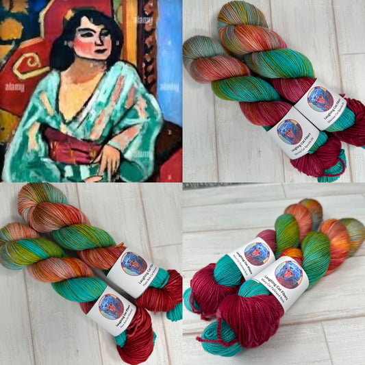 Colorful yarn skeins with labels on a wooden surface, inspired by a traditional painting.