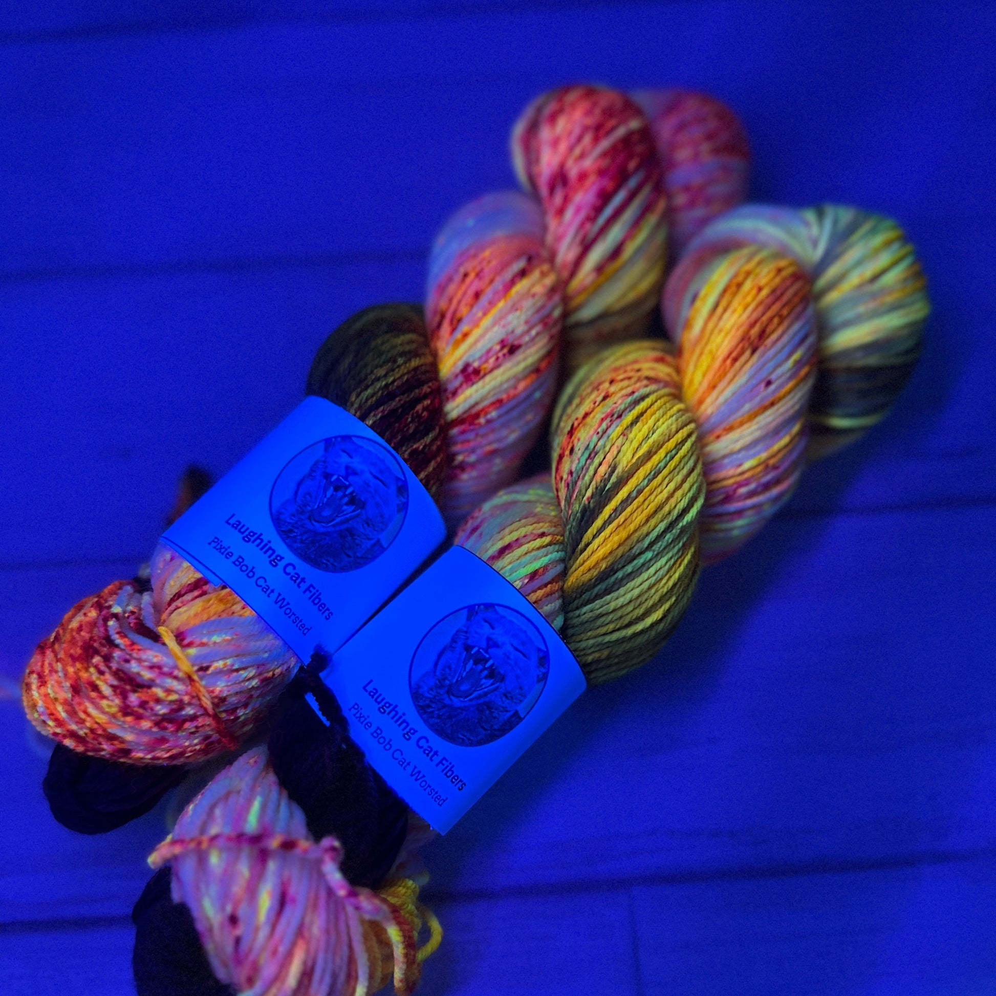 Hand dyed yarn by Laughing Cat Fibers under black light 