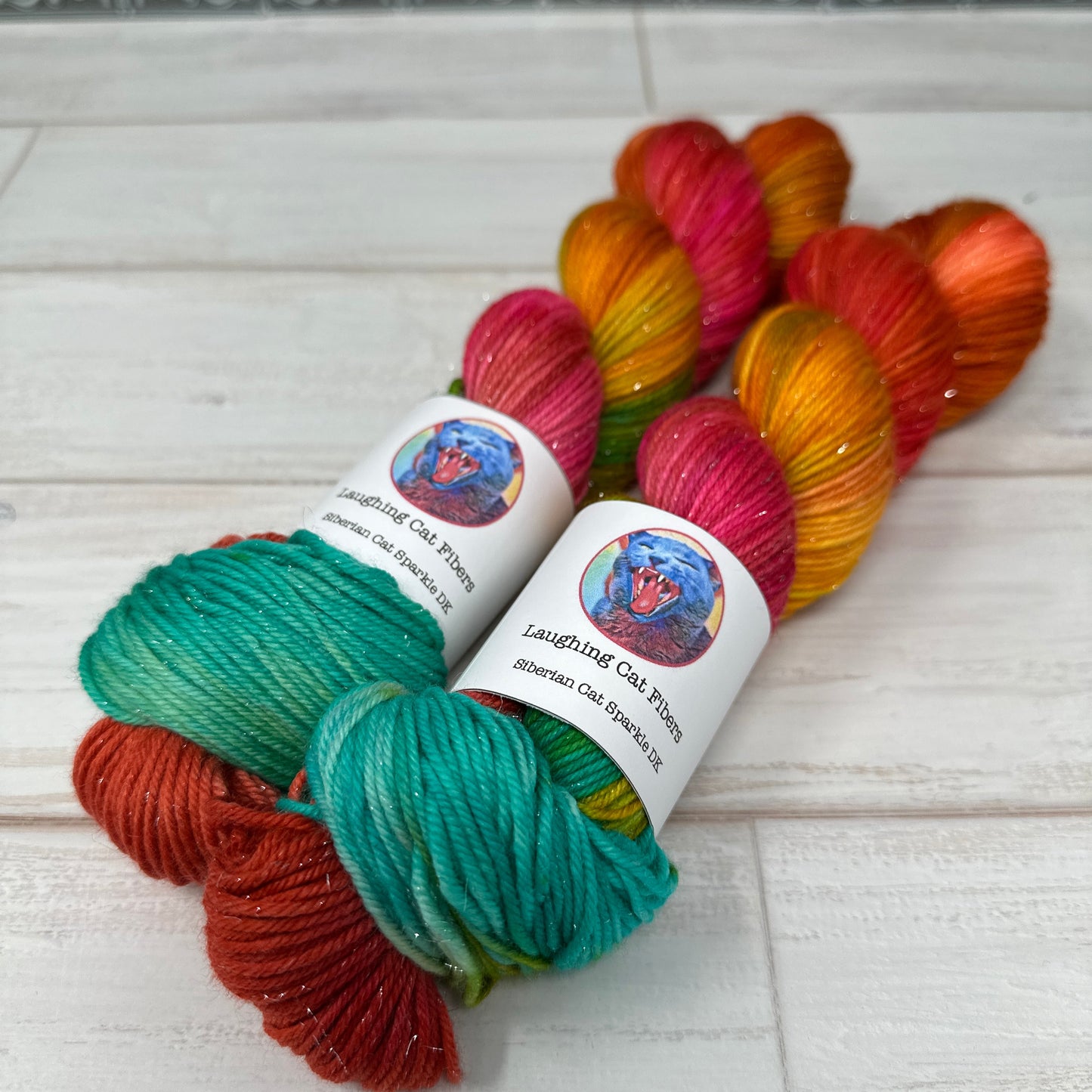 Colorful yarn skeins with labels on a white wooden surface