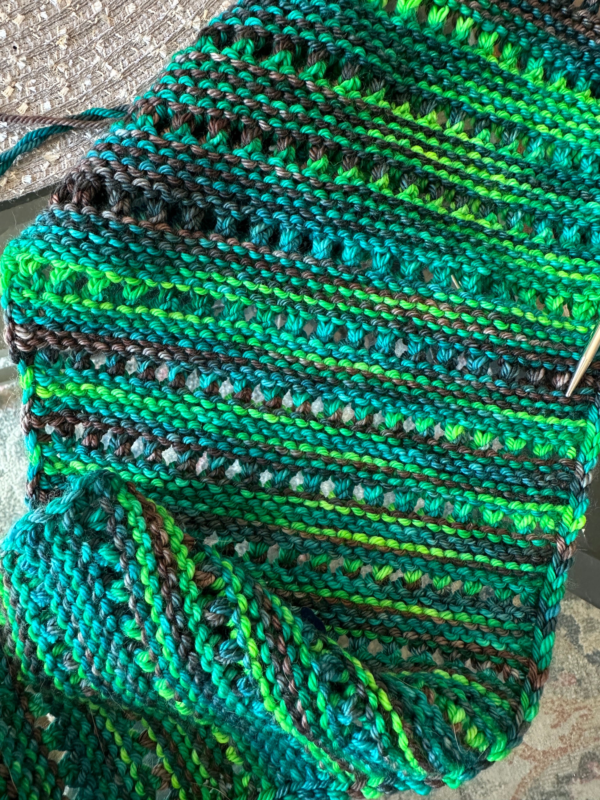 Knitted fabric with green and black pattern on a textured surface