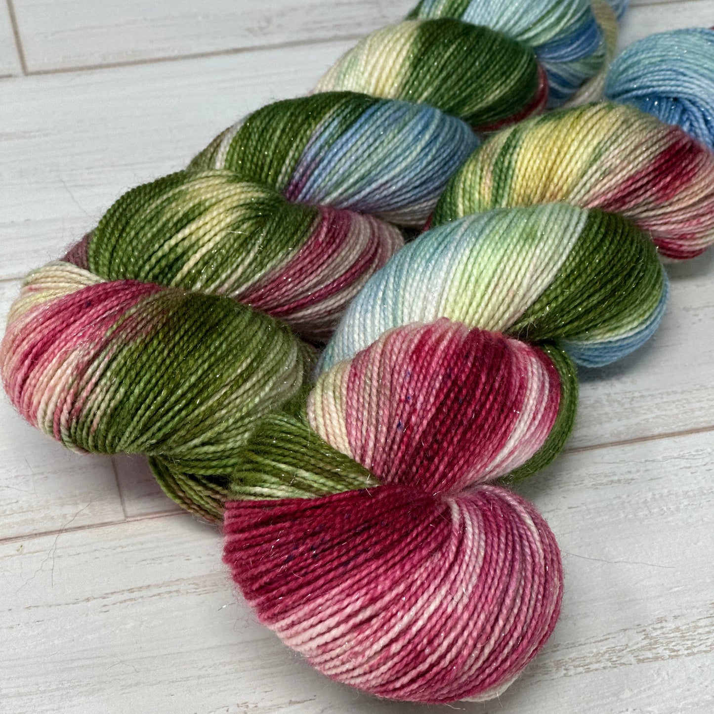 Multicolored skein of yarn shaped like a heart on a wooden surface