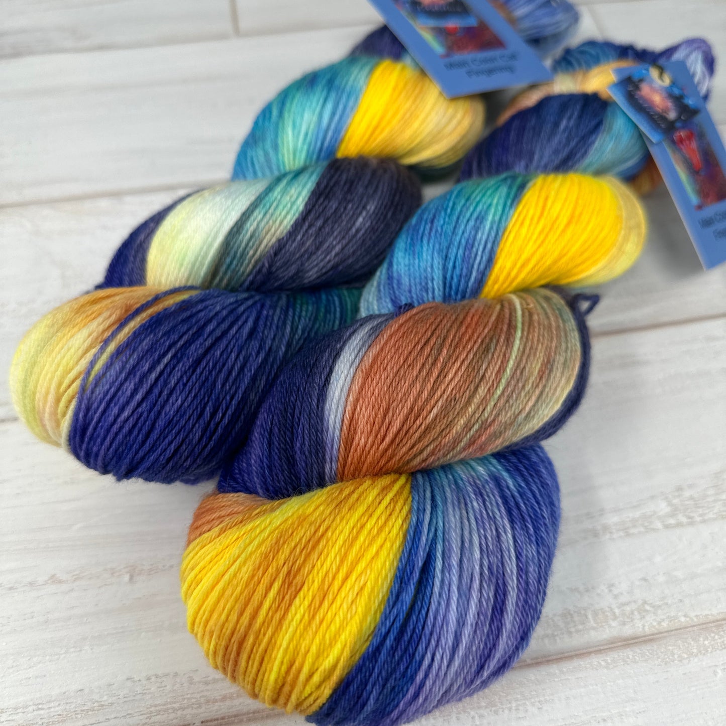Three skeins of multicolored yarn on a wooden surface