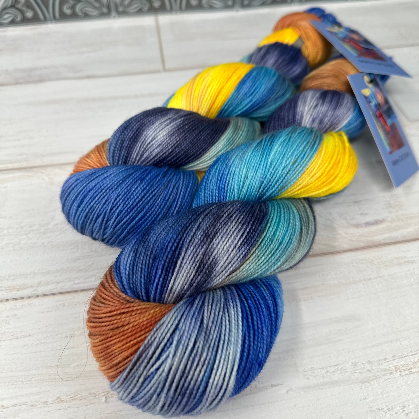 Multicolored yarn skeins on a wooden surface with a blurred background