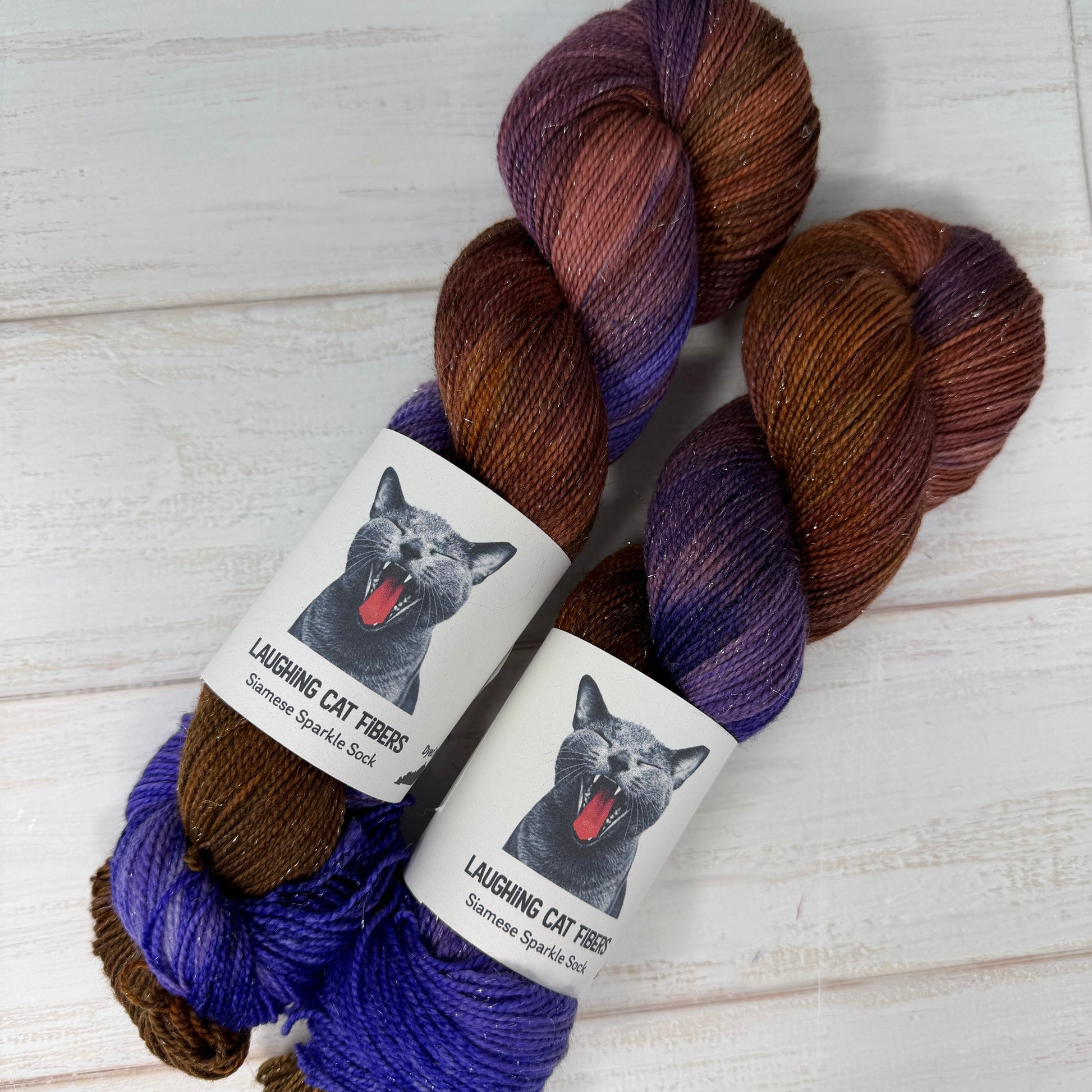 Two skeins of yarn with purple and brown tones based on the book The Color Purple