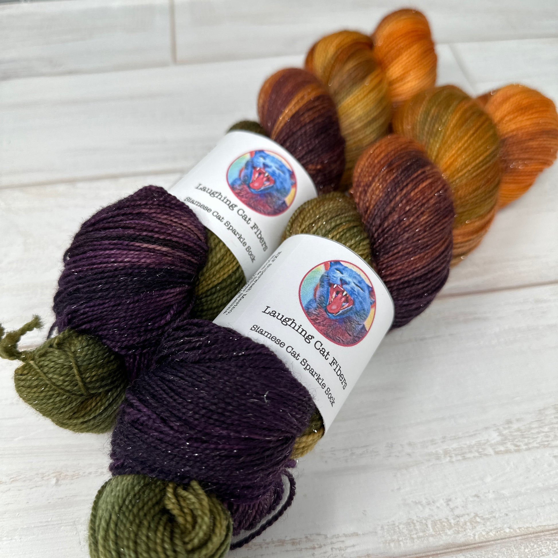 Three skeins of multicolored yarn with labels on a textured surface