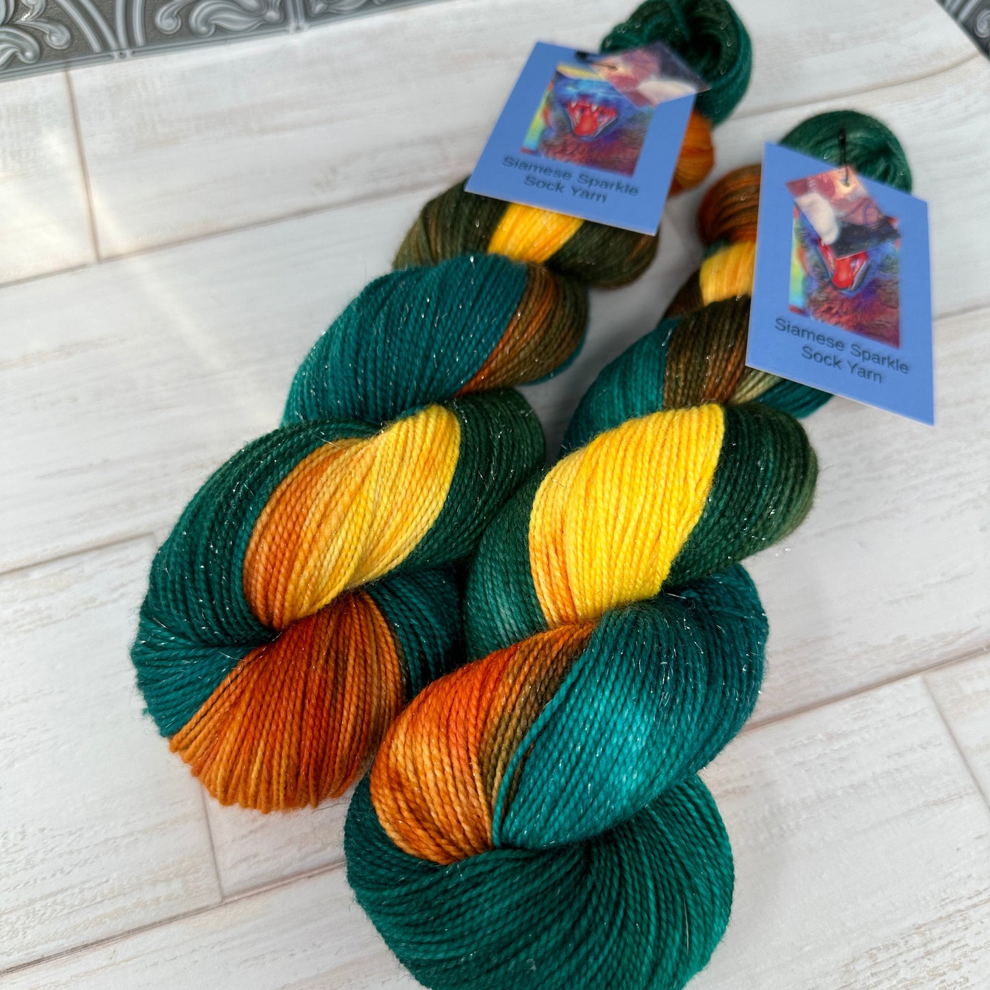 two skeins of sparkle sock yarn hand dyed by Laughing Cat Fibers in their colorway Goldfish 