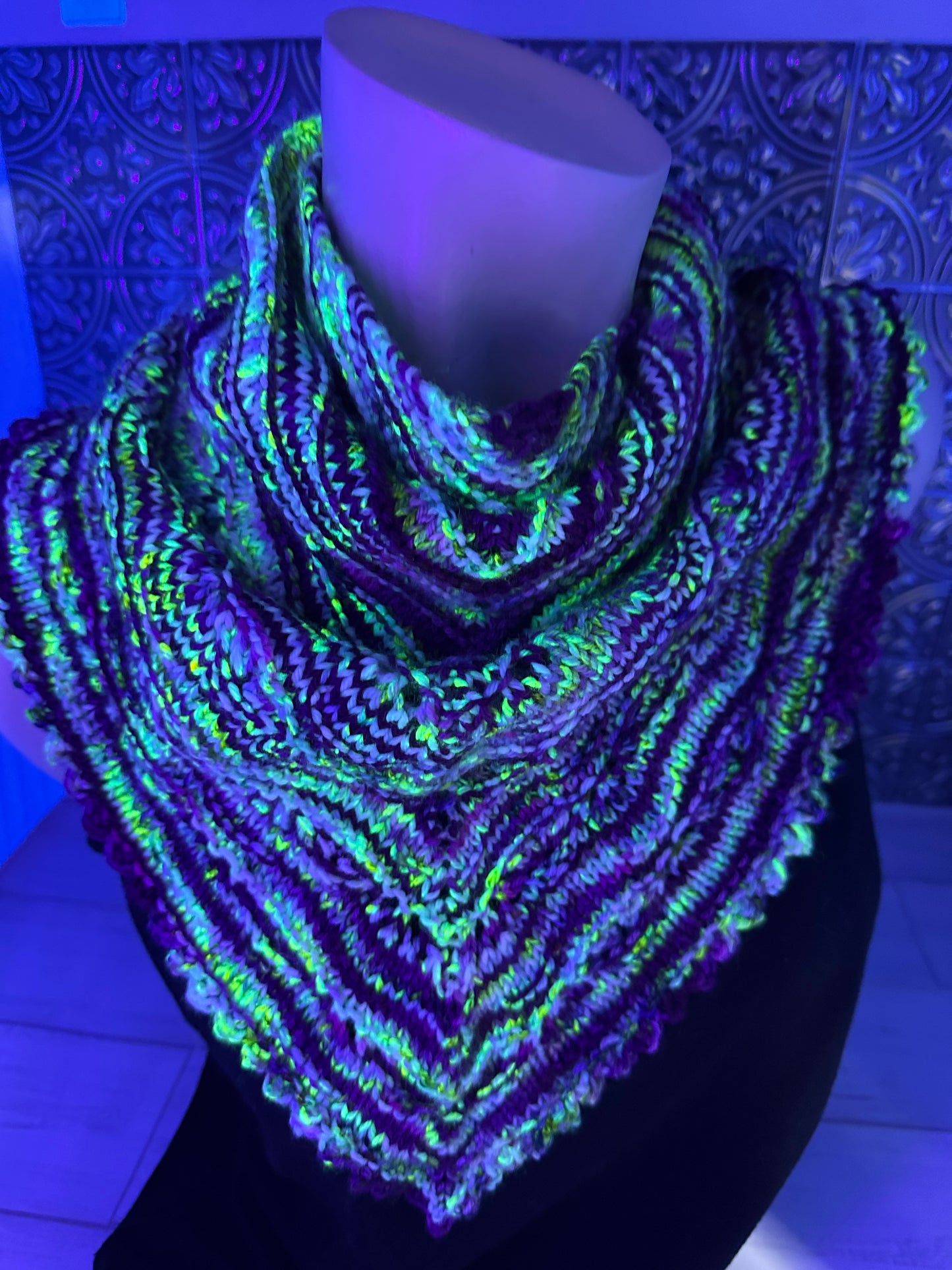 Glowing multicolored fabric under black light on a textured surface