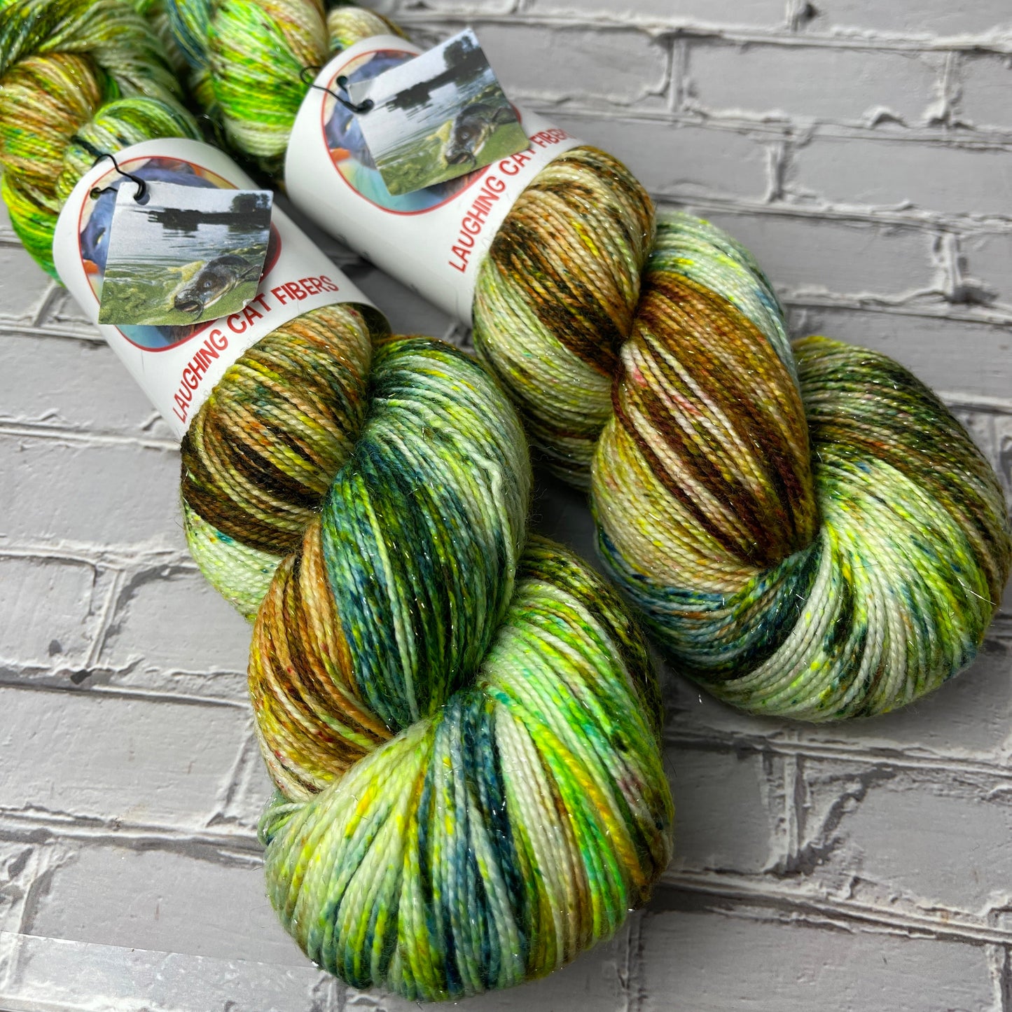 two skeins of hand dyed sparkle sock yarn by Laughing Cat Fibers